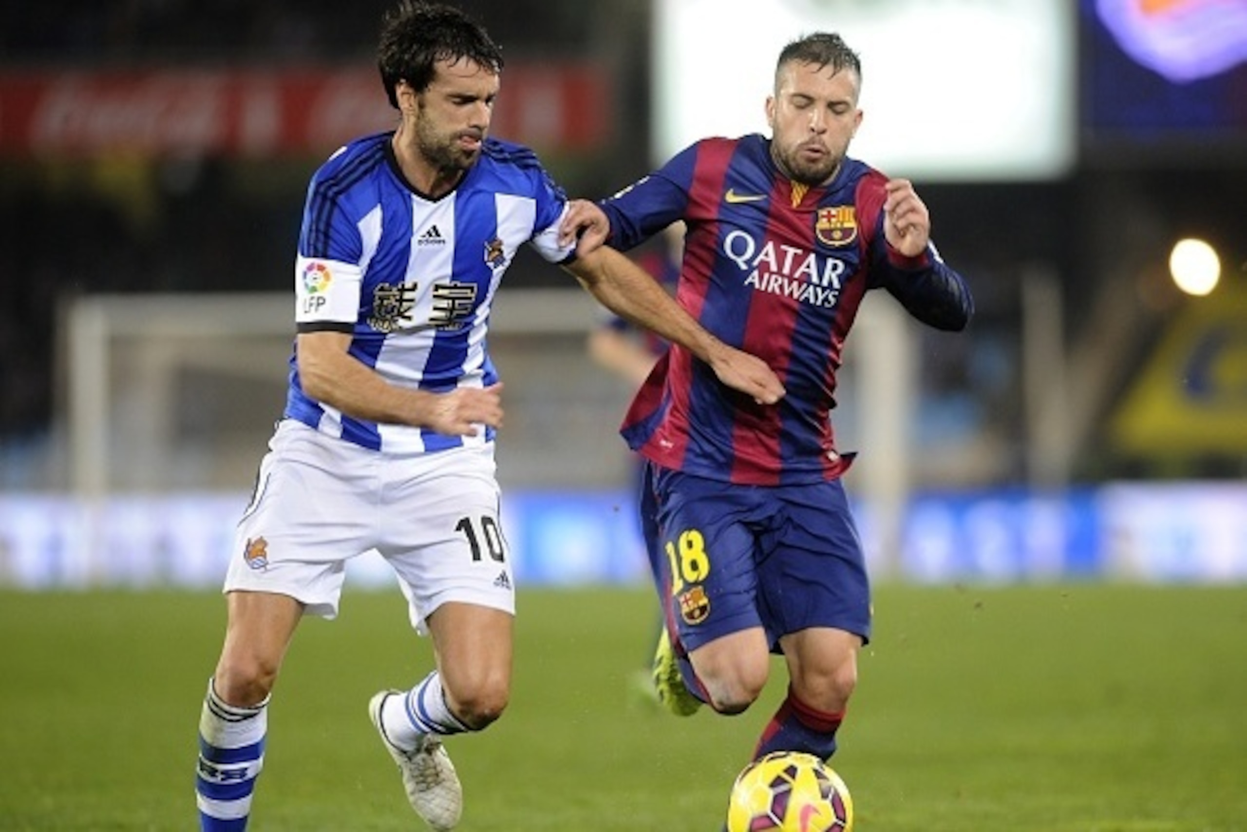 Barcelona's defender Jordi Alba (R) vies for the ball with Real Sociedad's midfielder Xabi Prieto (L) during the Spanish league football match Real Sociedad de Futbol vs FC Barcelona at the Anoeta stadium in San Sebastian on January 4, 2015. AFP PHOTO/ AN