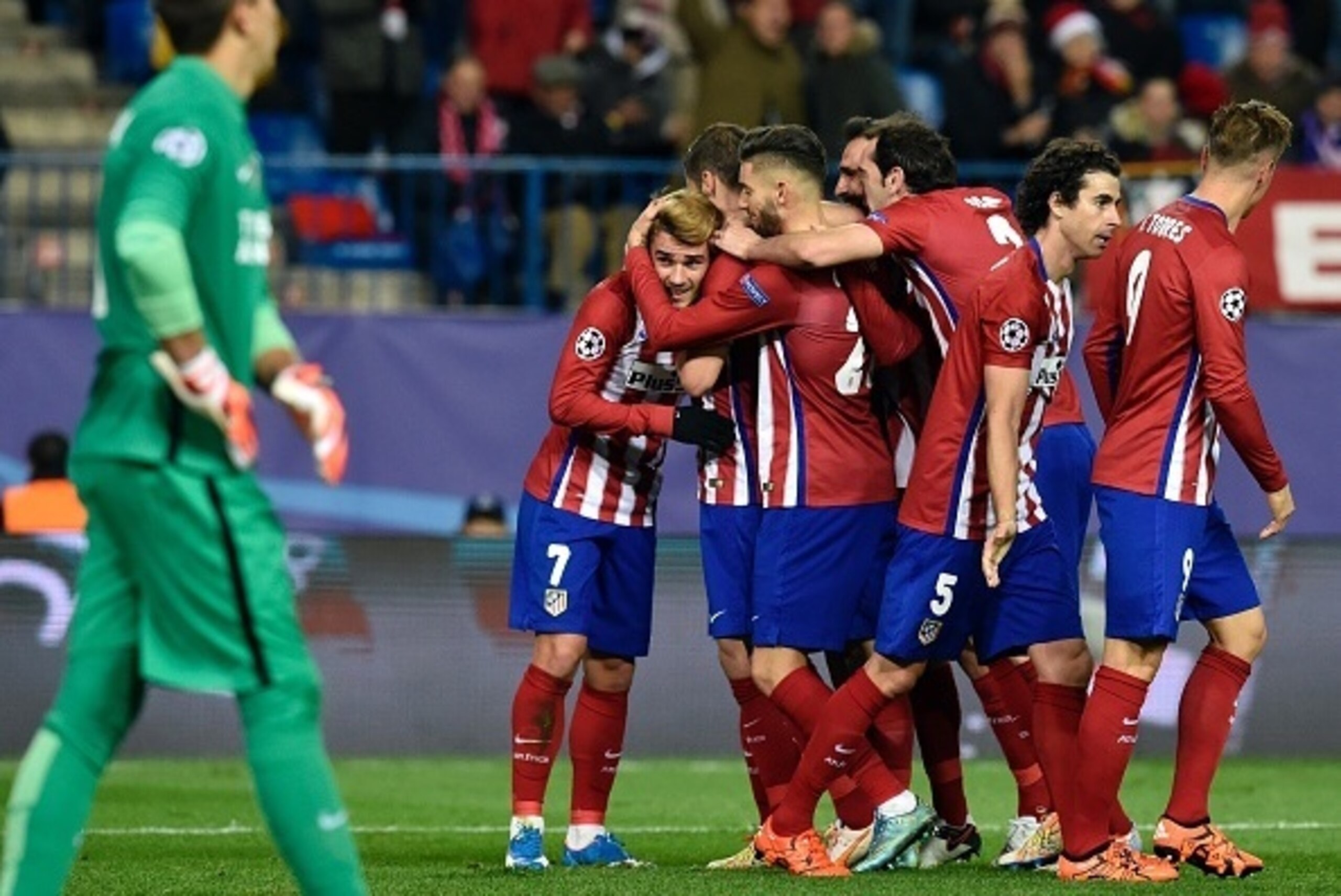Atletico Madrid's players congratulate teammate French forward Antoine Griezmann (L) after scoring a second goal during the UEFA Champions League Group C football match Club Atletico de Madrid vs Galatasaray AS at the Vicente Calderon stadium in Madrid on