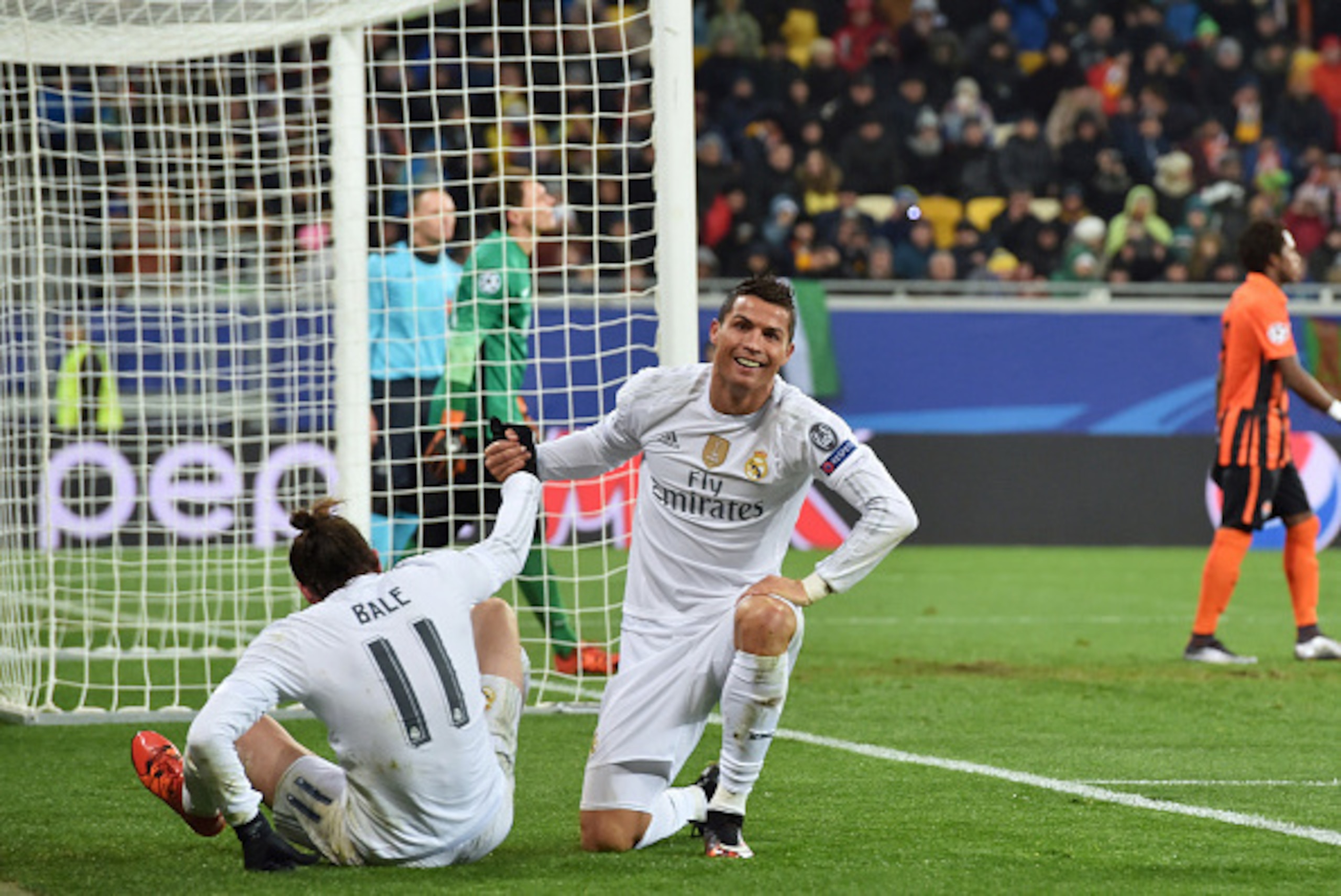 Real Madrid's Portuguese forward Cristiano Ronaldo (R) helps up his teammate Real Madrid's Welsh forward Gareth Bale during the UEFA Champions League group A football match between Shakhtar Donetsk and Real Madrid in Lviv on November 25, 2015. AFP PHOTO /