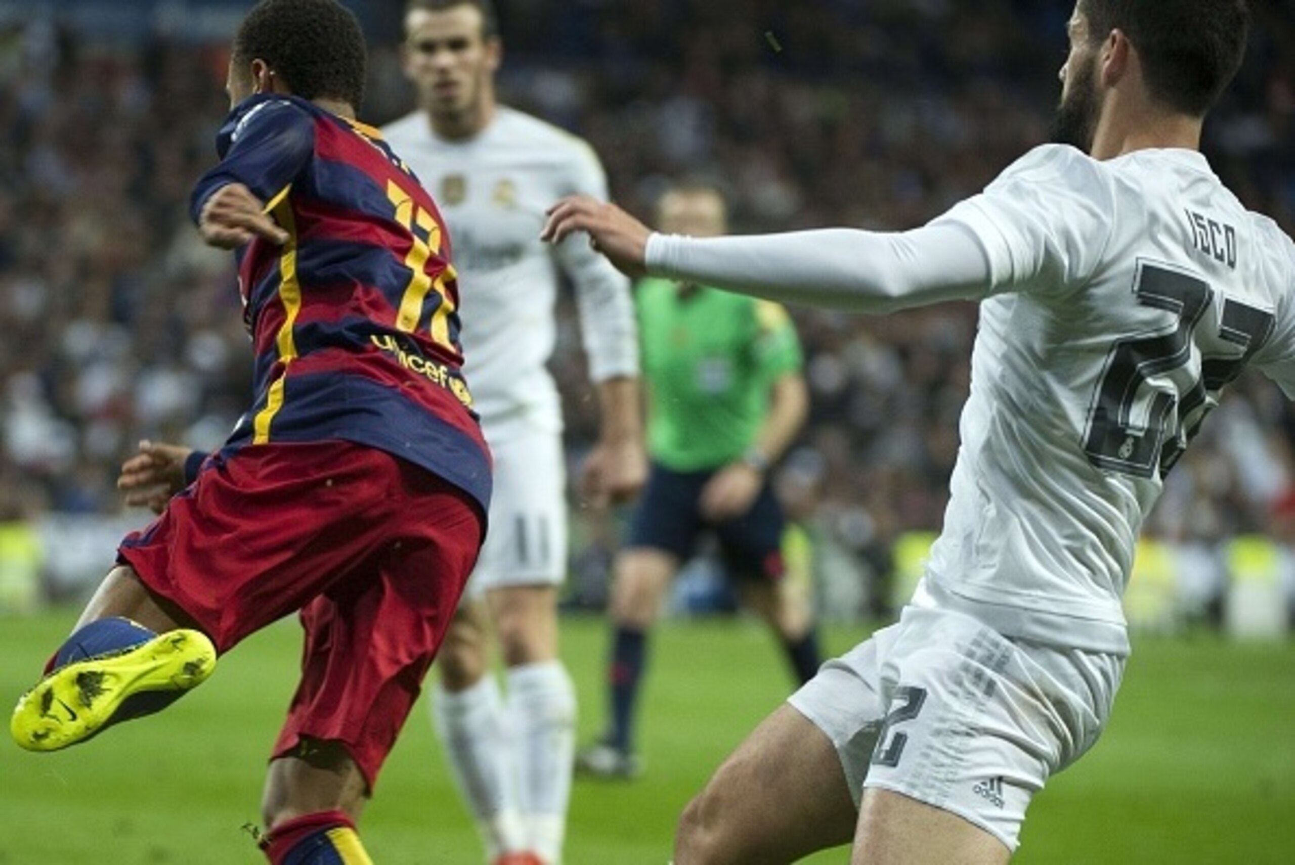 Real Madrid's midfielder Isco (R) tackles Barcelona's Brazilian forward Neymar (L) during the Spanish league 'Clasico' football match Real Madrid CF vs FC Barcelona at the Santiago Bernabeu stadium in Madrid on November 21, 2014. AFP PHOTO / CURTO DE LA T