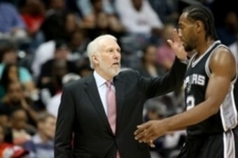 Oct 14, 2015; Atlanta, GA, USA; San Antonio Spurs head coach Gregg Popovich greets forward Kawhi Leonard (2) as he walk to the bench in the third quarter of their game against the Atlanta Hawks at Philips Arena. The Hawks won 100-86. Mandatory Credit: Jas