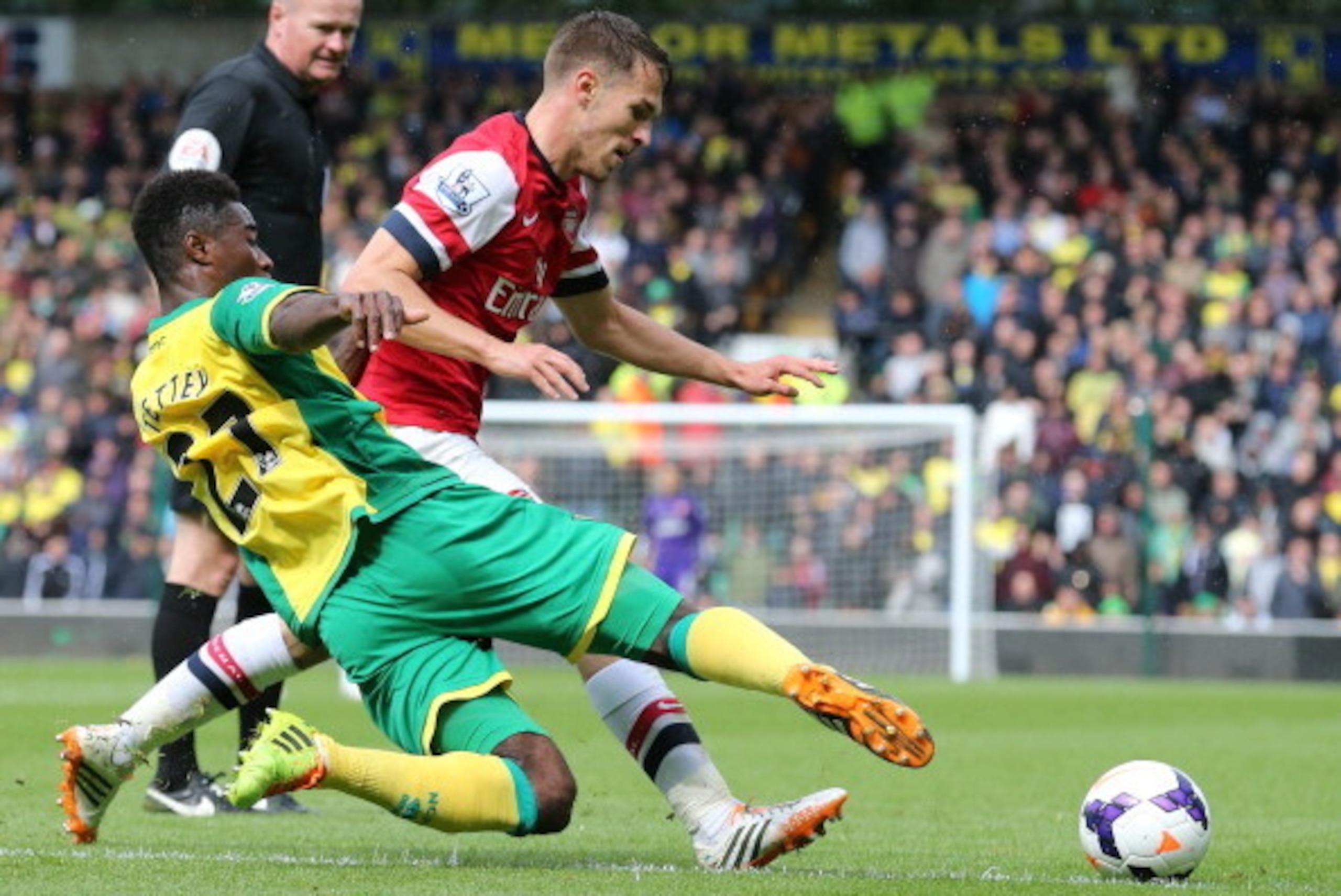 Norwich City's Ghanaian-born Norwegian midfielder Alexander Tettey (L) tackles Arsenal's Welsh midfielder Aaron Ramsey during the English Premier League football match between Norwich City and Arsenal at Carrow Road in Norwich on May 11, 2014.  AFP PHOTO/