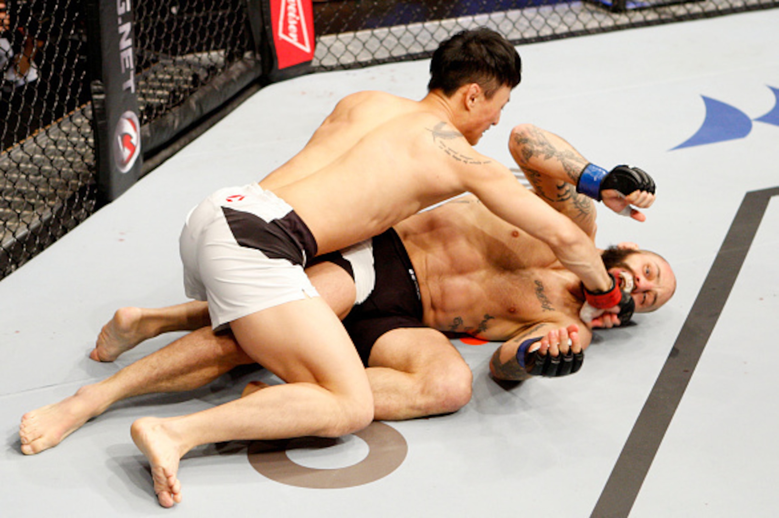 SEOUL, SOUTH KOREA - NOVEMBER 28: Doo Ho Choi of South Korea punches Sam Sicilia of the United States of America in their  featherweight bout during the UFC Fight Night at the Olympic Park Gymnastics Arena on November 28, 2015 in Seoul, South Korea. (Phot