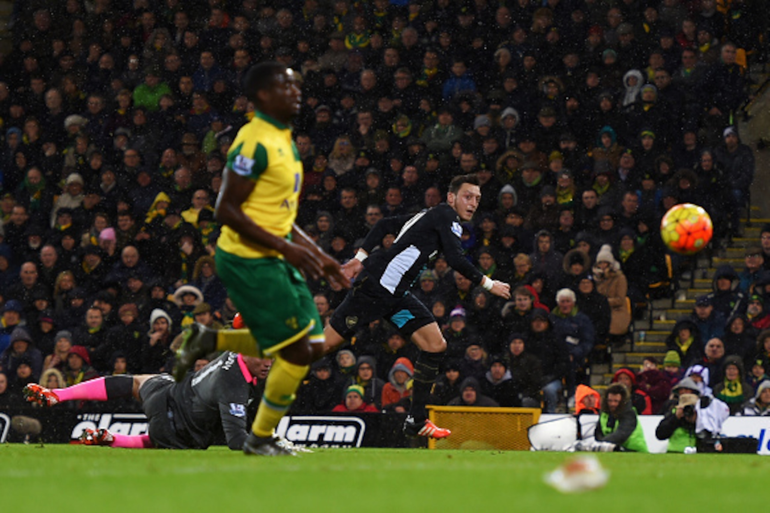 NORWICH, ENGLAND - NOVEMBER 29:  Mesut Ozil of Arsenal beats goalkeeper John Ruddy of Norwich City to score their first goal during the Barclays Premier League match between Norwich City and Arsenal at Carrow Road on November 29, 2015 in Norwich, England.