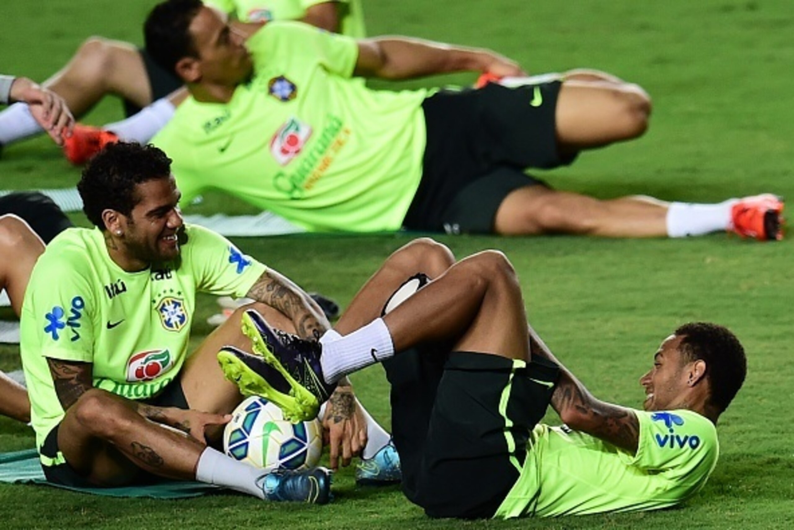 Brazilian player Neymar Junior (R) jokes with Daniel Alves during a training session in Salvador, Brazil on November 16, 2015, on the eve of a FIFA World Cup Russia 2018 qualifier match against Peru. AFP PHOTO / CHRISTOPHE SIMON        (Photo credit shoul