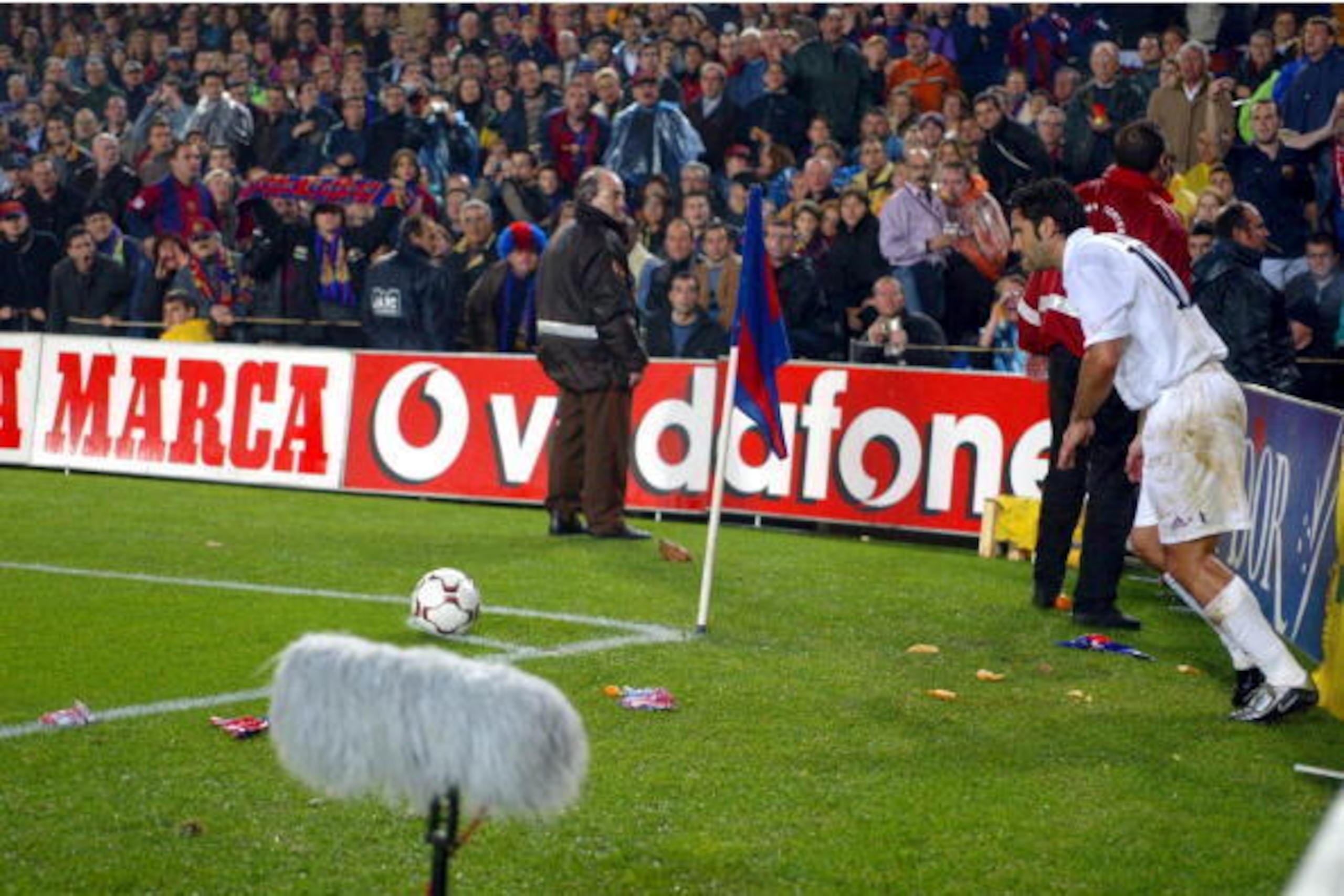 BARCELONA - NOVEMBER 23:  Luis Figo of Real Madrid is bombarded by missiles as he attempts to take a corner during the La Liga match between FC Barcelona and Real Madrid played at the Nou Camp Stadium, Barcelona, Spain on November 23, 2002. (Photo by Firo