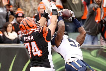 CINCINNATI, OH - NOVEMBER 29:  Jake Fisher #74 of the Cincinnati Bengals and Daren Bates #53 of the St. Louis Rams reach for the ball at Paul Brown Stadium on November 29, 2015 in Cincinnati, Ohio.  (Photo by Andy Lyons/Getty Images)