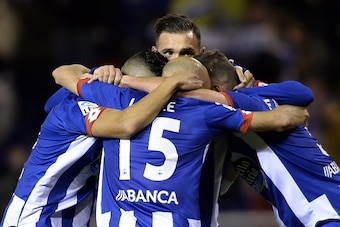 Deportivo La Coruna's midfielder Lucas Perez (C) hugs teammates celebrating their second goal during the Spanish league football match RC Deportivo La Coruna vs Celta Vigo at the Municipal de Riazor stadium in La Coruna on November 21, 2015. Deportivo won