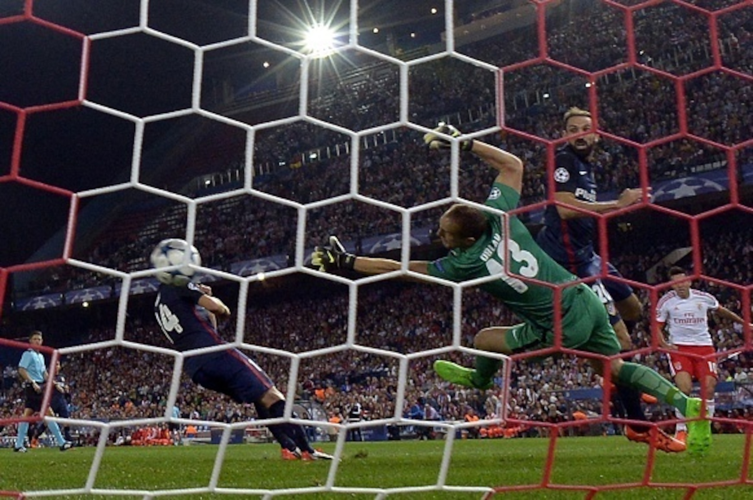 Atletico Madrid's Slovenian goalkeeper Jan Oblak (C) tries to stop a shoot of Benfica's Argentinian midfielder Nicolas Gaitan (R) during the UEFA Champions League football match Club Atletico de Madrid vs SL Benfica at the Vicente Calderon stadium in Madr