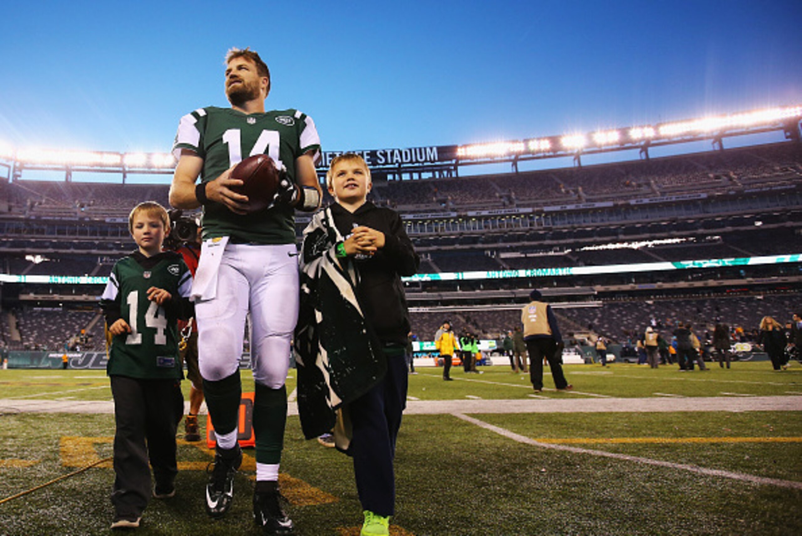 EAST RUTHERFORD, NJ - NOVEMBER 29:  Ryan Fitzpatrick #14 of the New York Jets walks off the field with his children after their 38-20 win against the Miami Dolphin at MetLife Stadium on November 29, 2015 in East Rutherford, New Jersey.  (Photo by Al Bello