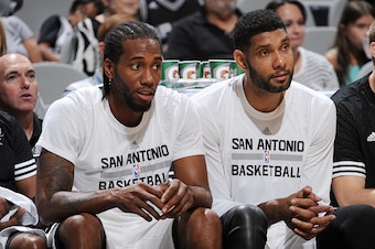 SAN ANTONIO, TX - OCTOBER 18:  Kawhi Leonard #2 of the San Antonio Spurs and Tim Duncan #21 of the San Antonio Spurs sit on the bench against the Detroit Pistons during a preseason game on October 18, 2015 at the AT&T Center in San Antonio, Texas. NOTE TO