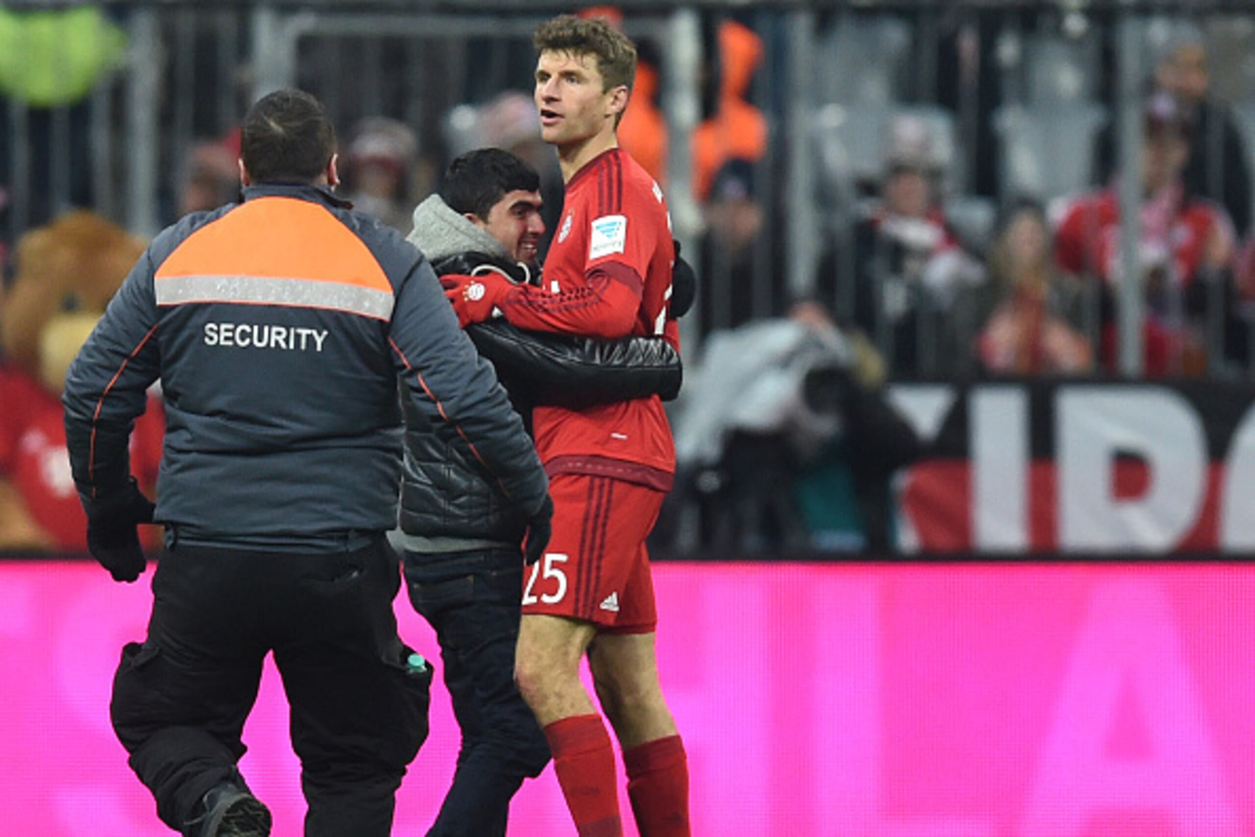 A supporter embraces Bayern Munich's striker Thomas Mueller (R) during the German first division Bundesliga football match FC Bayern Munich vs Hertha Berlin in Munich, southern Germany, on November 28, 2015.  AFP PHOTO / CHRISTOF STACHE

RESTRICTIONS: DUR