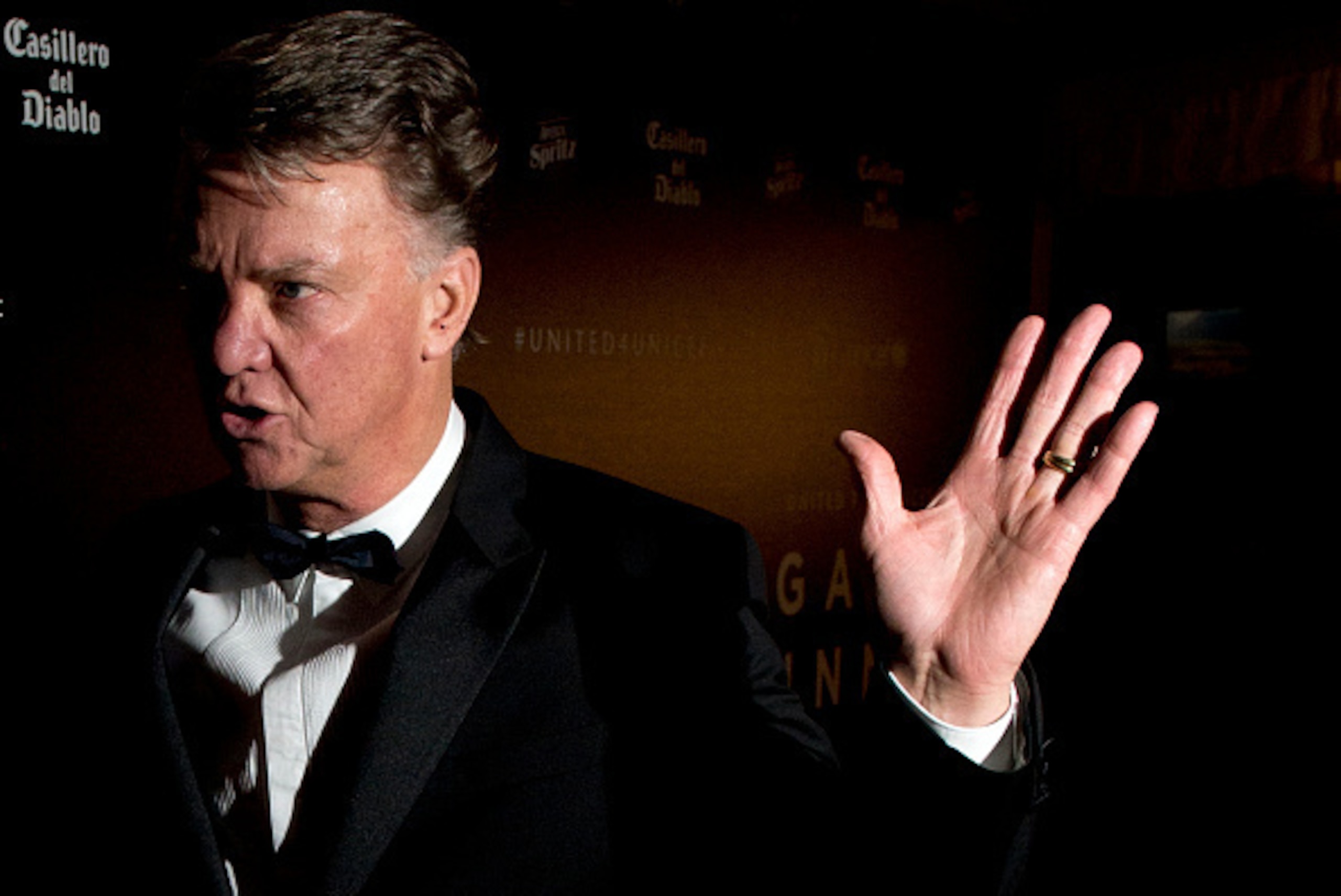 Manchester United's Dutch manager Louis van Gaal gestures towards photographers after posing for pictures on the red carpet as he arrives to attend the 'United for UNICEF Gala Dinner' at Old Trafford in Manchester, north-west England, on November 29, 2015