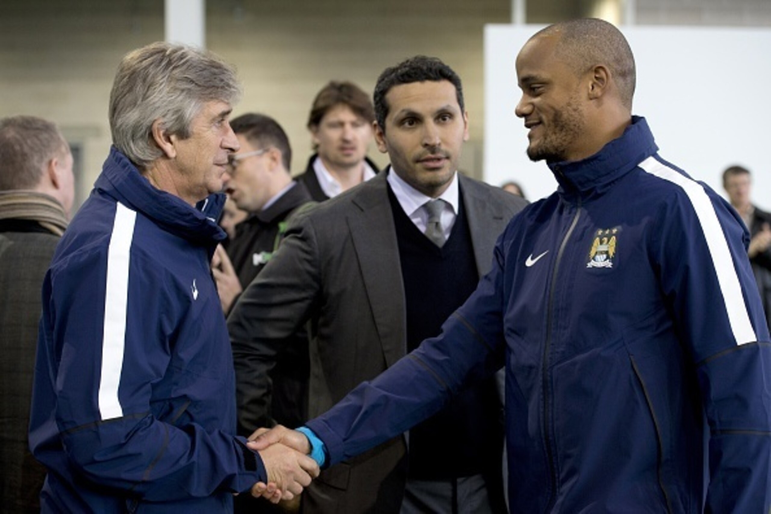 Manchester City's chairman Emirati Khaldoon al-Mubarak (C) looks on as Manchester City's Chilean manager Manuel Pellegrini (L) and Manchester City's Belgian defender Vincent Kompany (R) shake hands during the official launch of the City Football Academy i