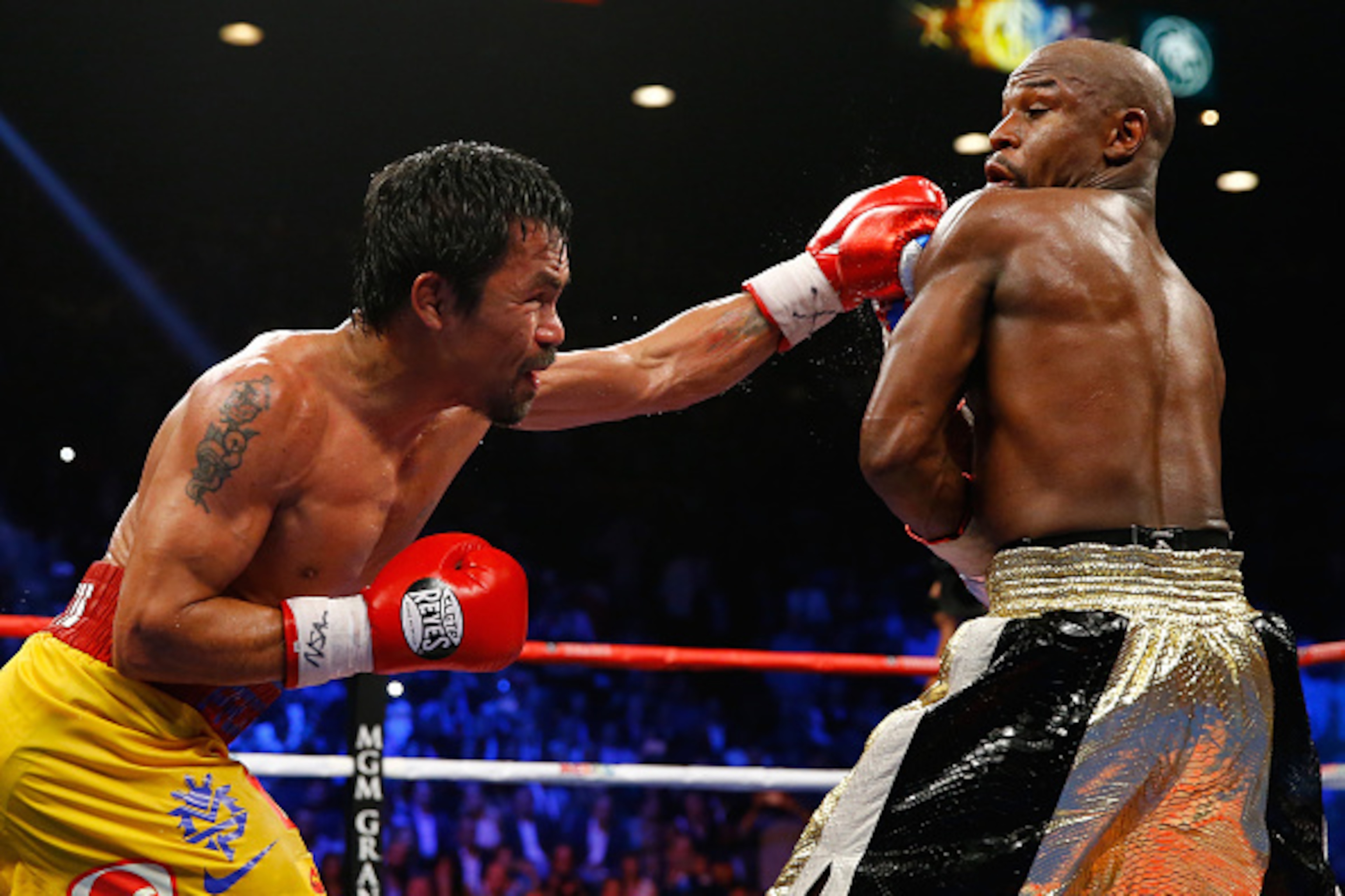 LAS VEGAS, NV - MAY 02:  Manny Pacquiao throws a left at Floyd Mayweather Jr. during their welterweight unification championship bout on May 2, 2015 at MGM Grand Garden Arena in Las Vegas, Nevada.  (Photo by Al Bello/Getty Images)