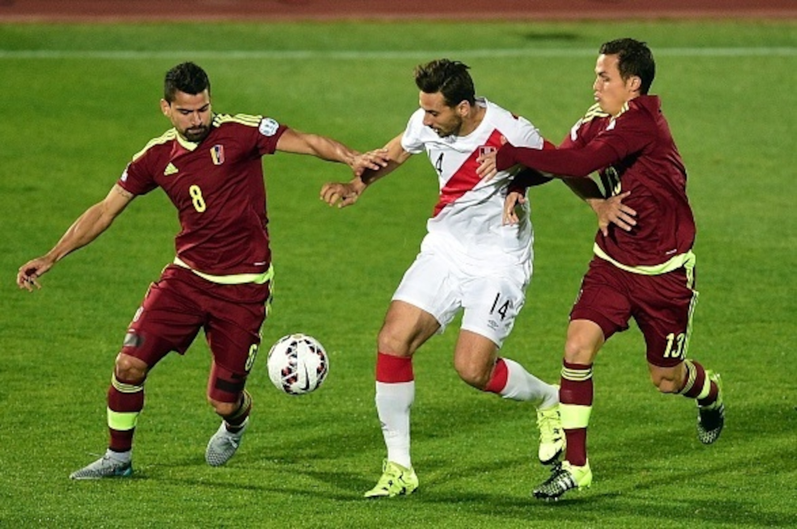 Peru's forward Claudio Pizarro (C) is marked by Venezuela's Tomas Rincon (L) and Luis Seijas during their 2015 Copa America football championship match, in Valparaiso, Chile, on June 18, 2015.   AFP PHOTO / RONALDO SCHEMIDT        (Photo credit should rea