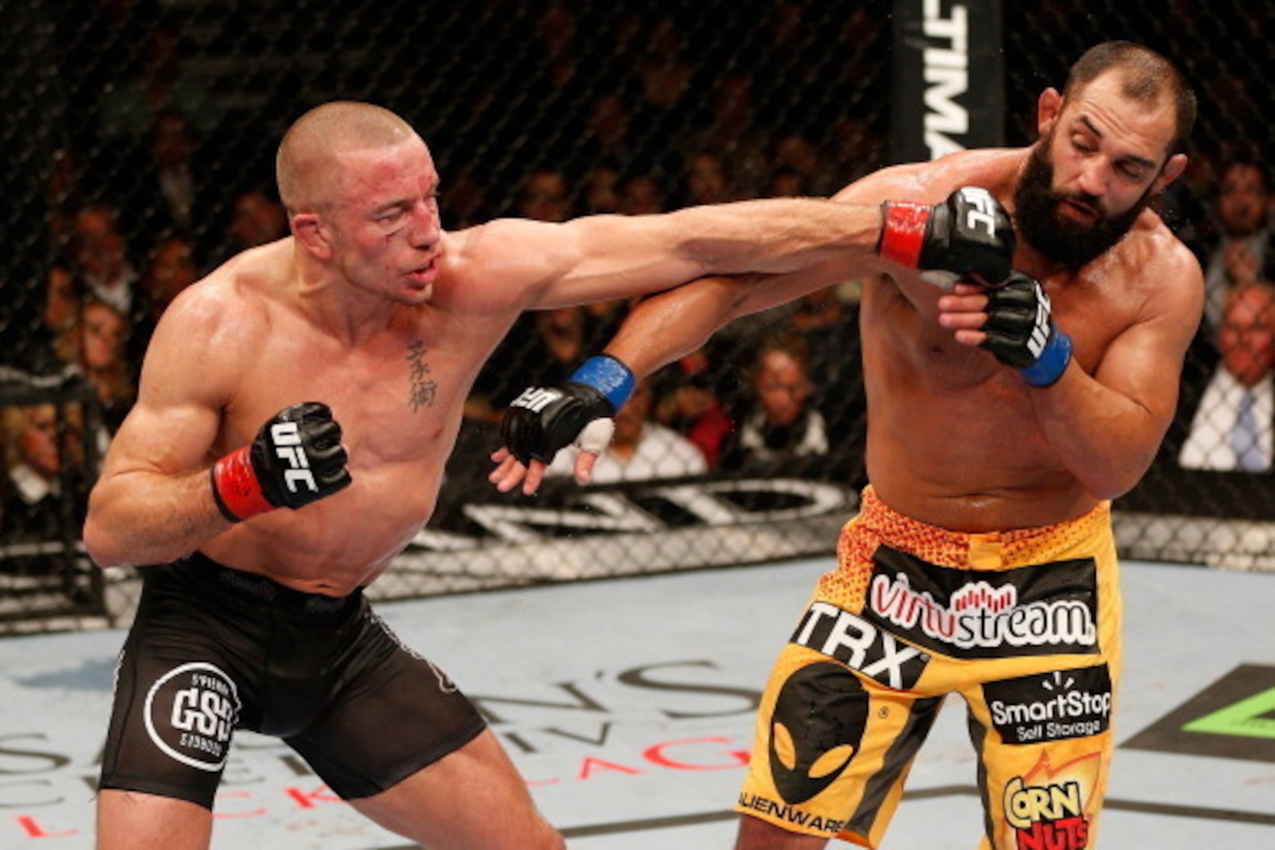 LAS VEGAS, NV - NOVEMBER 16:  (L-R) Georges St-Pierre punches Johny Hendricks in their UFC welterweight championship bout during the UFC 167 event inside the MGM Grand Garden Arena on November 16, 2013 in Las Vegas, Nevada. (Photo by Josh Hedges/Zuffa LLC