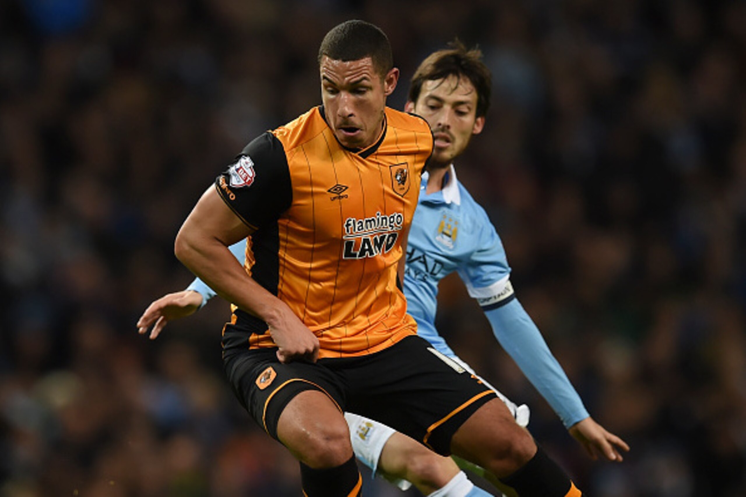 Hull City's English midfielder Jake Livermore (L) tries to twist away from Manchester City's Spanish midfielder David Silva (R) during the English League Cup quarter-final football match between Manchester City and Hull City at the Etihad Stadium in Manch