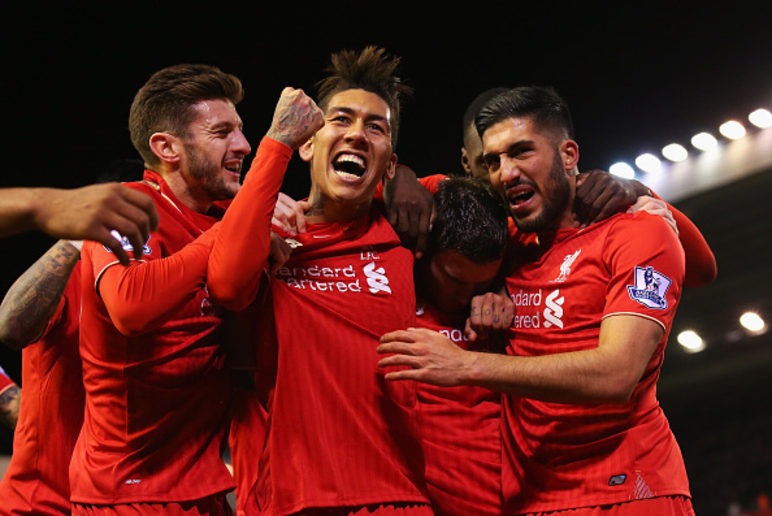 LIVERPOOL, ENGLAND - NOVEMBER 29:  James Milner of Liverpool (2R) is congratulated by Adam Lallana (L), Roberto Firmino (2L), Emre Can (R) as he scores their first goal from a penalty during the Barclays Premier League match between Liverpool and Swansea 