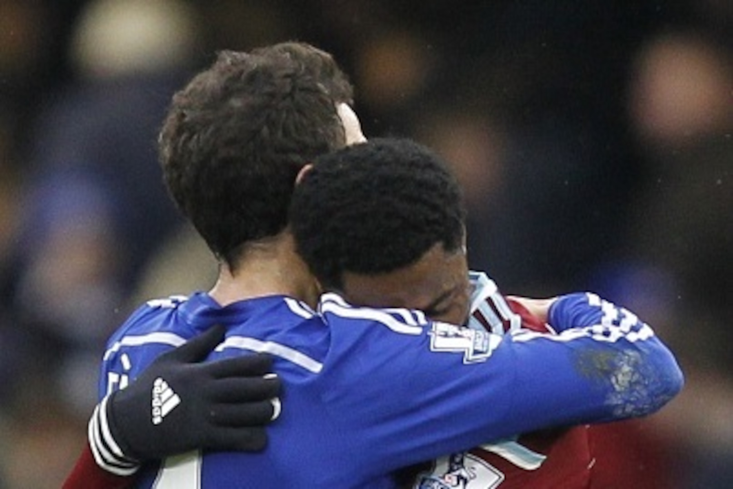 Ex-teammates at Arsenal, West Ham United's Cameroonian midfielder Alex Song (R) and Chelsea's Spanish midfielder Cesc Fabregas (L) embrace at the final whistle in the English Premier League football match between Chelsea and West Ham United at Stamford Br