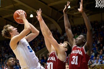 DURHAM, NC - DECEMBER 02:  Luke Kennard #5 of the Duke Blue Devils shoots against Collin Hartman #30 and Thomas Bryant #31 of the Indiana Hoosiers during their game at Cameron Indoor Stadium on December 2, 2015 in Durham, North Carolina.  (Photo by Grant 