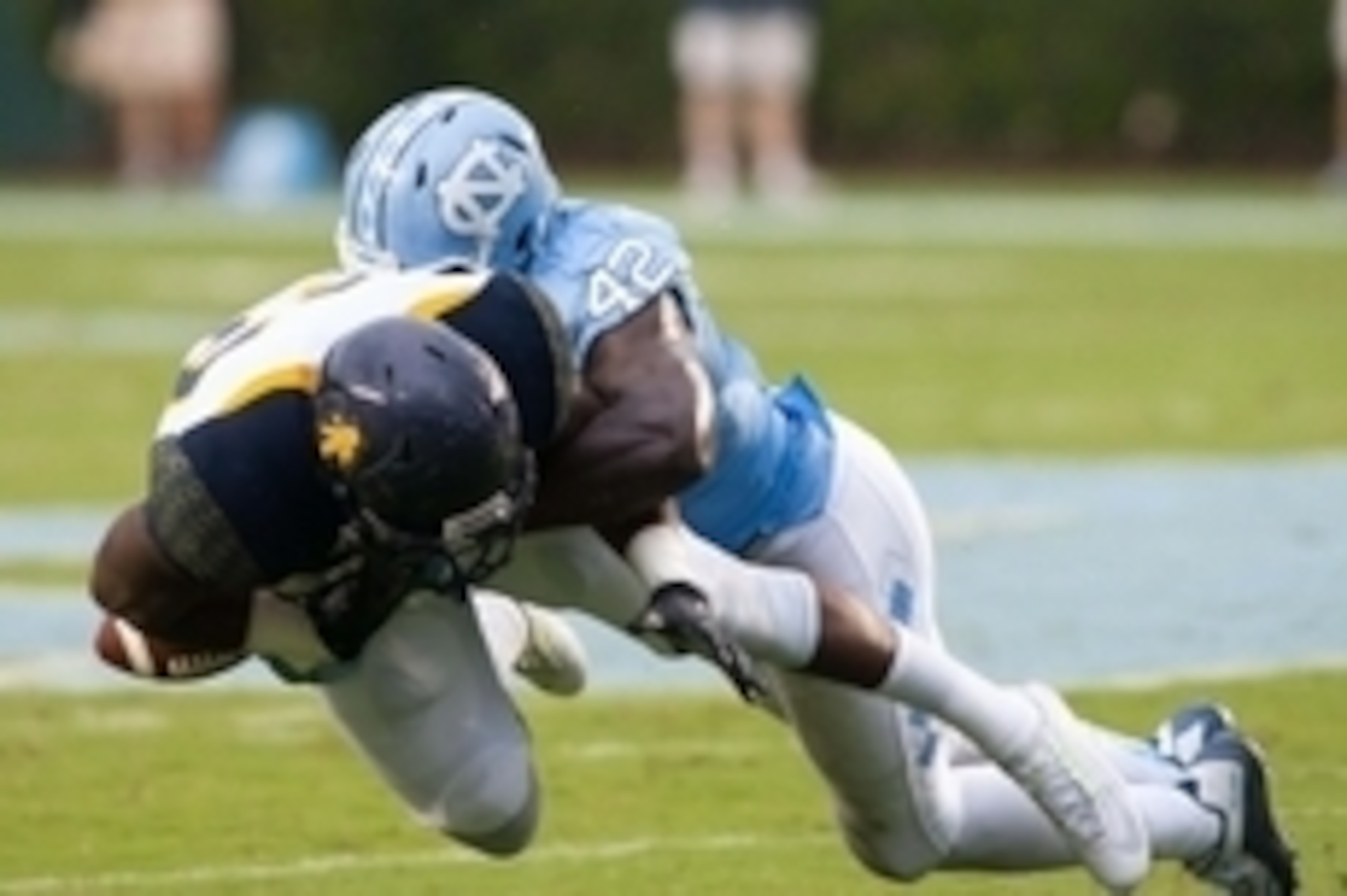 Sep 12, 2015; Chapel Hill, NC, USA; North Carolina Tar Heels linebacker Shakeel Rashad (42) knocks the ball loose from North Carolina A&T Aggies running back Justin Smith (22) during the first quarter at Kenan Memorial Stadium. Mandatory Credit: Jeremy Br