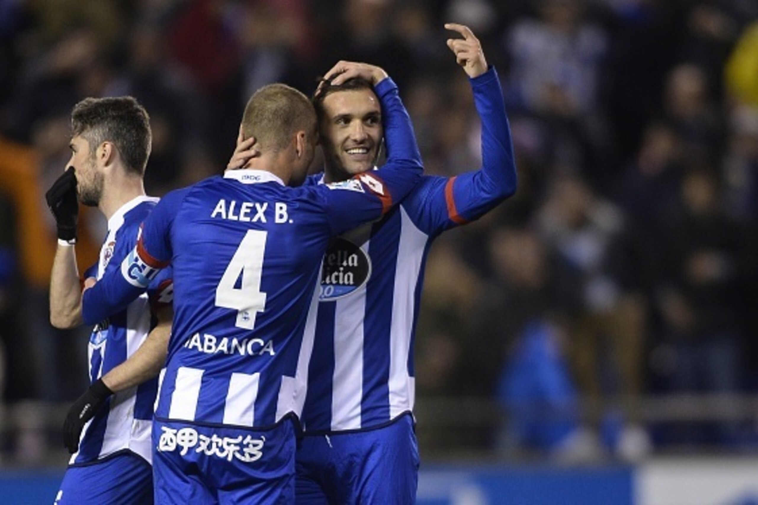 Deportivo La Coruna's midfielder Lucas Perez (R) hugs his teammate midfielder Alex Bergantinos  after scoring their second goal during the Spanish league football match RC Deportivo La Coruna vs Celta Vigo at the Municipal de Riazor stadium in La Coruna o
