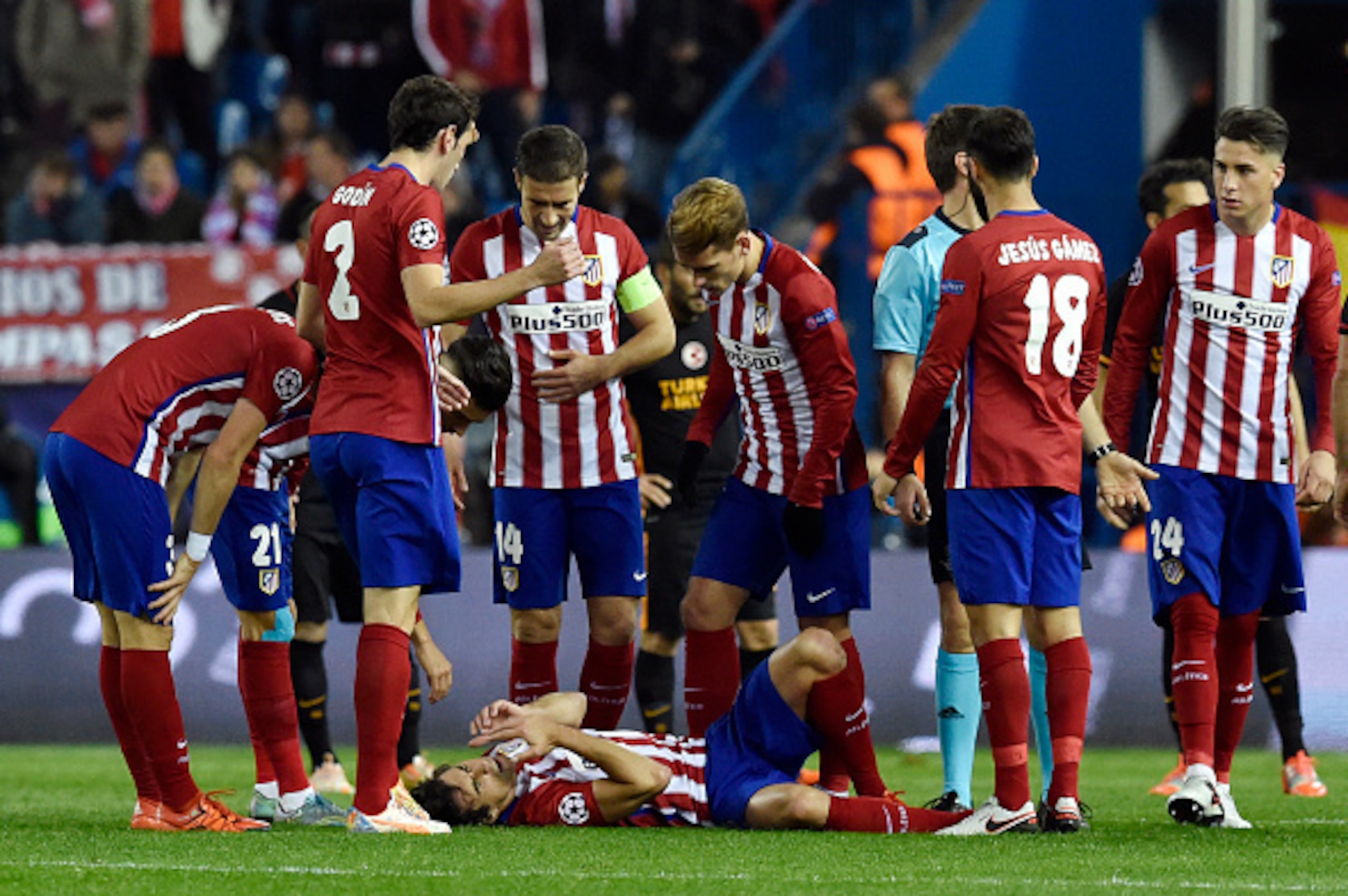 Atletico Madrid's Portuguese midfielder Tiago (bottom) lies on the pitch after being injured during the UEFA Champions League Group C football match Club Atletico de Madrid vs Galatasaray AS at the Vicente Calderon stadium in Madrid on November 25, 2015. 
