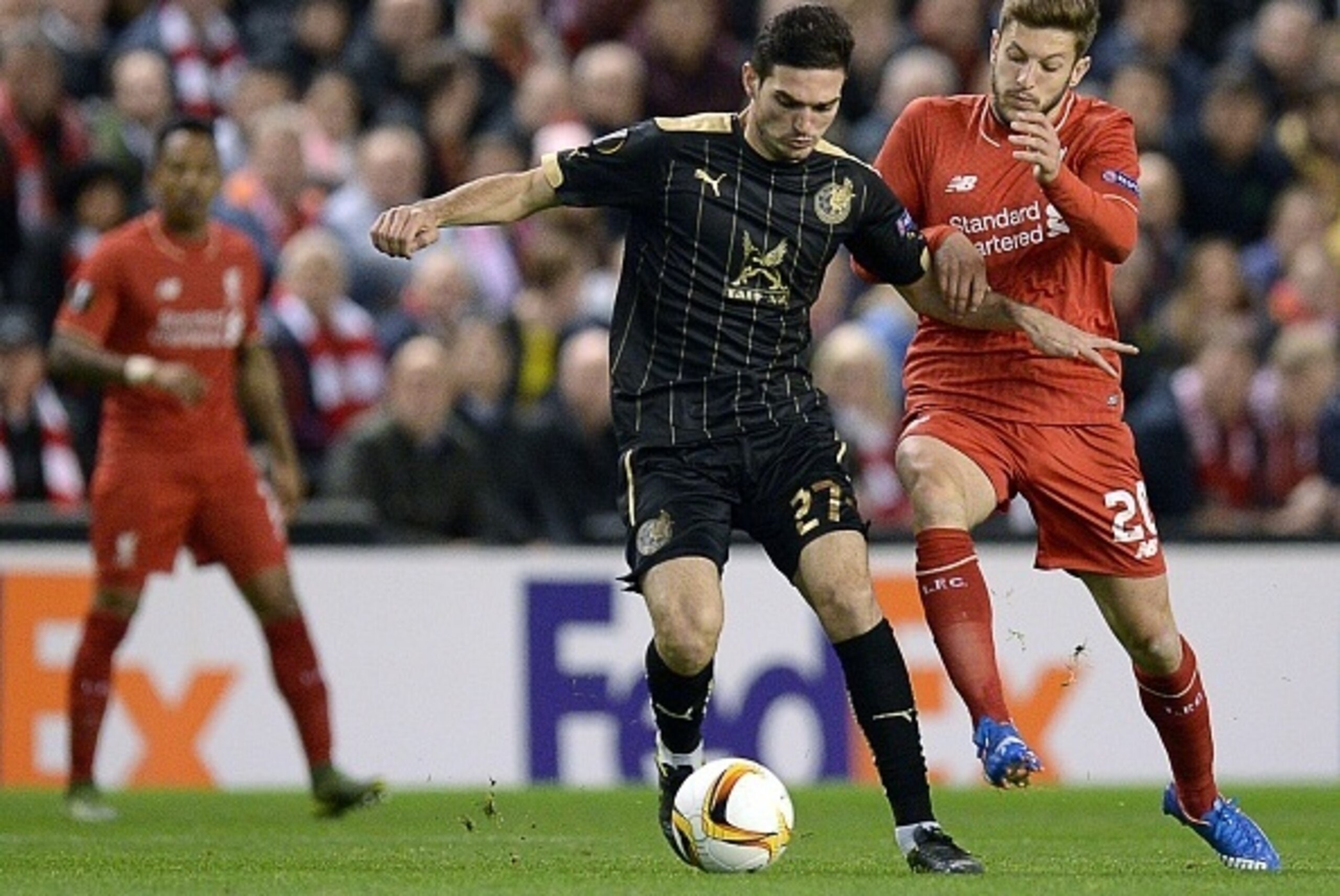 Rubin Kazan's Russian midfielder Magomed Ozdoev (C)  vies for the ball with Liverpool's English midfielder Adam Lallana (R) during a UEFA Europa League group B football match between Liverpool FC and FC Rubin Kazan at Anfield in Liverpool, north west Engl