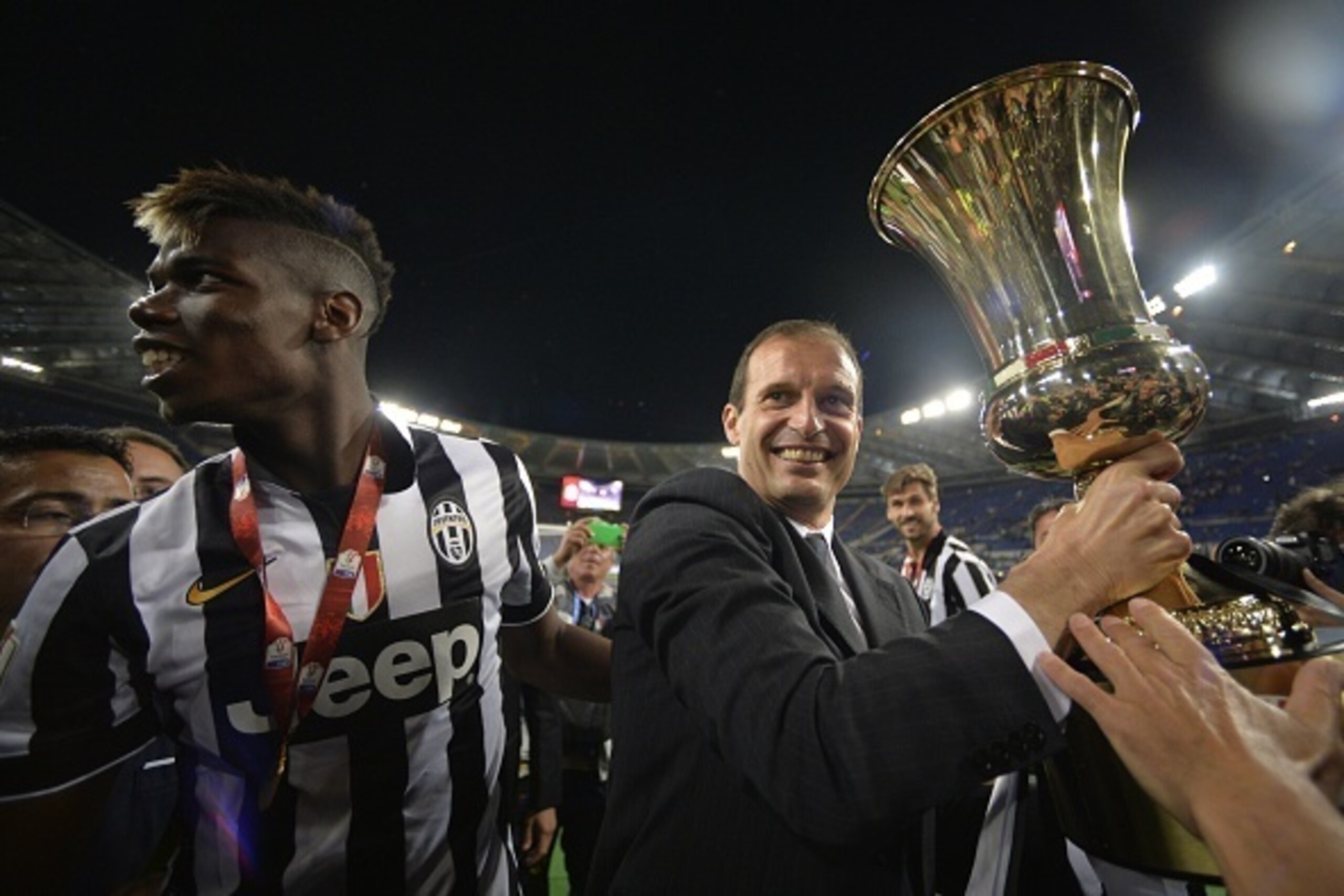 Juventus' coach Massimiliano Allegri (R) and Juventus' midfielder from France Paul Pogba celebrate with the trophy after winning 2-1 the Italian Tim Cup final match (Coppa Italia) between Juventus and Lazio on May 20, 2015 at the Stadio Olimpico in Rome. 