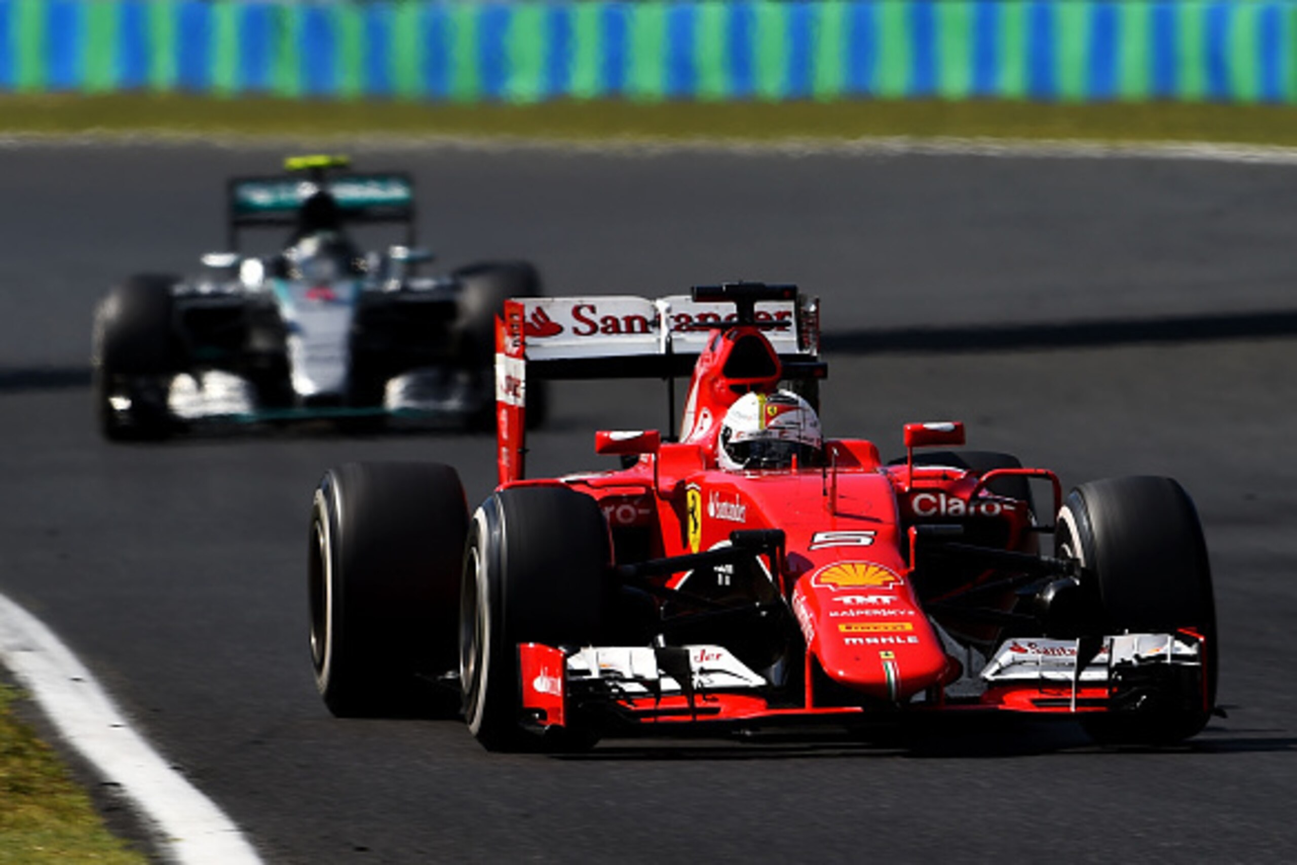 BUDAPEST, HUNGARY - JULY 26:  Sebastian Vettel of Germany and Ferrari drives ahead of Nico Rosberg of Germany and Mercedes GP during the Formula One Grand Prix of Hungary at Hungaroring on July 26, 2015 in Budapest, Hungary.  (Photo by Lars Baron/Getty Im