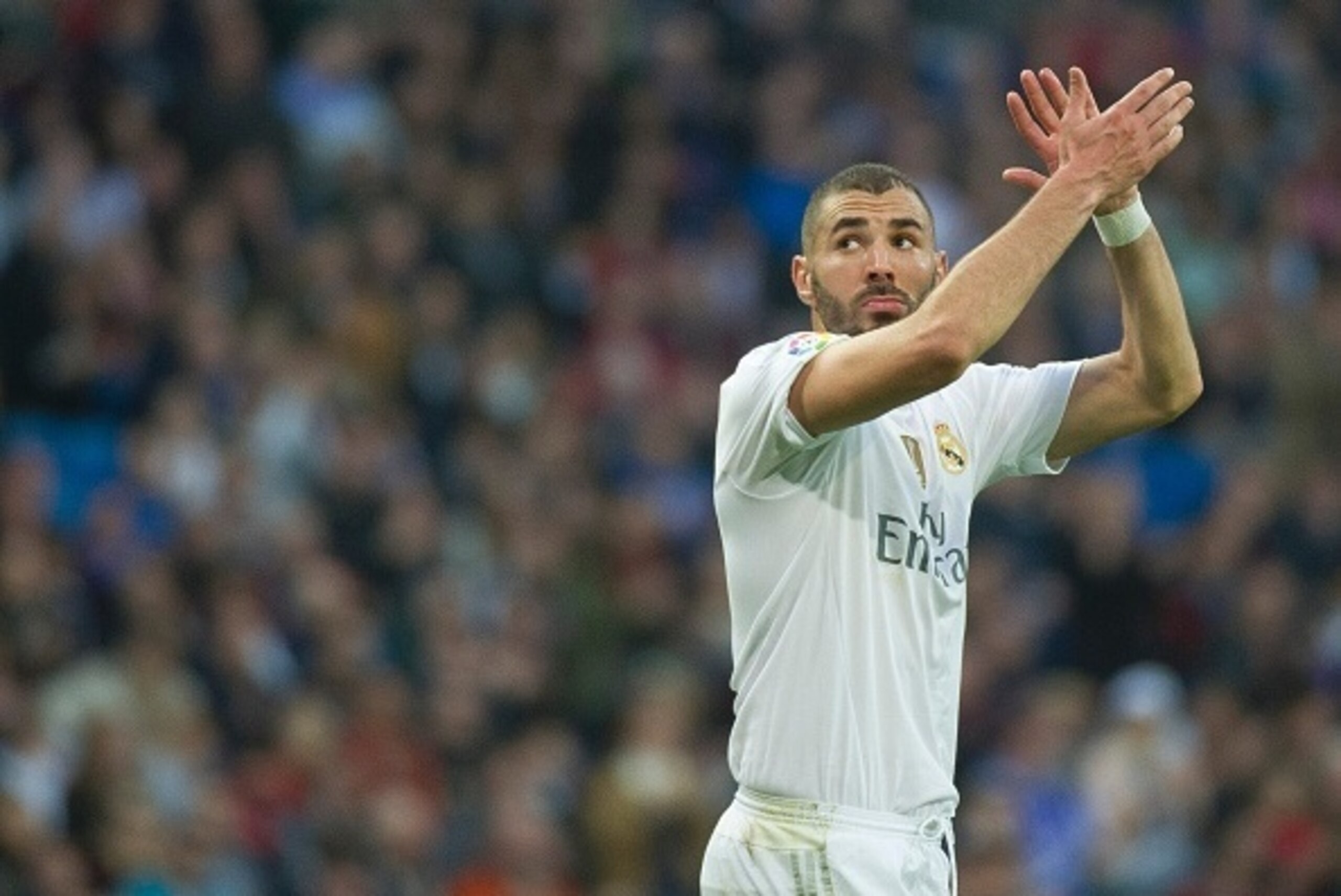 Real Madrid's French forward Karim Benzema greets supporters as he leaves the pitch during the Spanish league football match Real Madrid CF vs Getafe CF at the Santiago Bernabeu stadium in Madrid on December 5, 2015. AFP PHOTO / CURTO DE LA TORRE / AFP / 