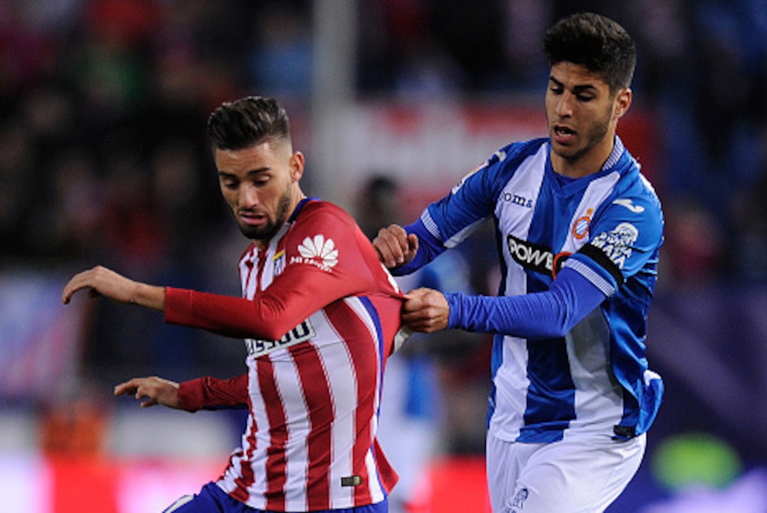 MADRID, SPAIN - NOVEMBER 28:  Yannick Carrasco of Club Atletico de Madrid is tackled by Marco Asensio of  Real CD Espanyol during the La Liga match between Club Atletico de Madrid and Real CD Espanyol at Vicente Calderon Stadium on November 28, 2015 in Ma