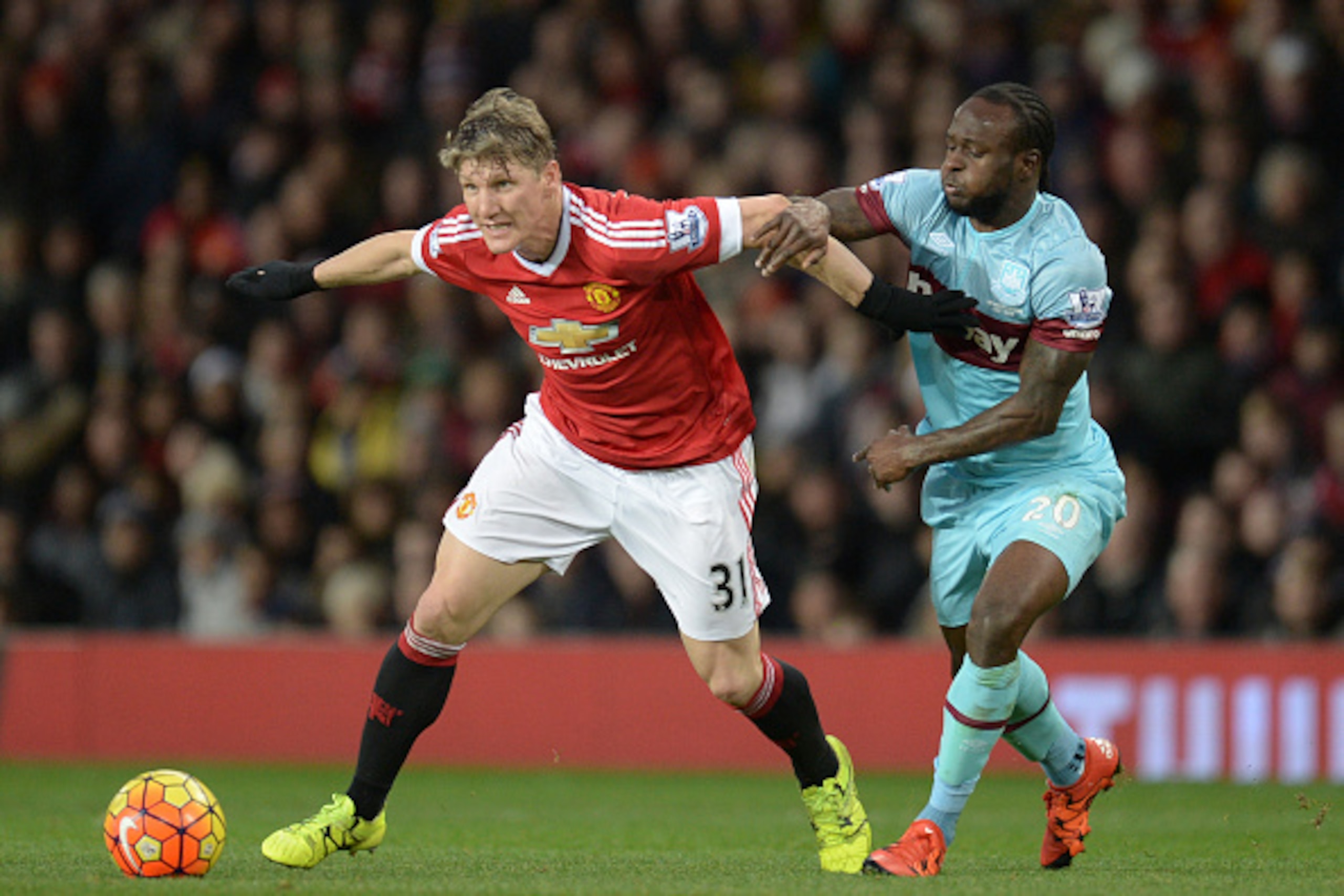 Manchester United's German midfielder Bastian Schweinsteiger (L) holds off West Ham United's Nigerian midfielder Victor Moses during the English Premier League football match between Manchester United and West Ham United at Old Trafford in Manchester, nor