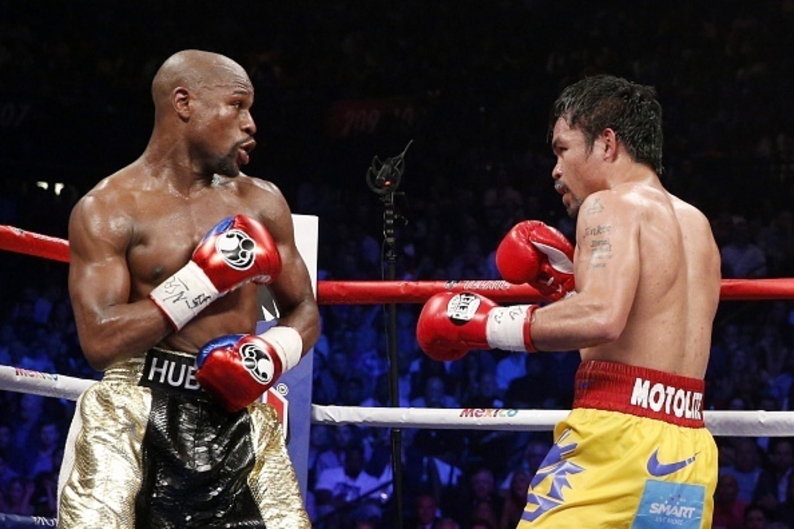 Floyd Mayweather Jr. exchange punches with Manny Pacquiao during their welterweight unification championship bout, May 2, 2015 at MGM Grand Garden Arena in Las Vegas, Nevada.  Mayweather defeated Pacquiao by unanimous decision.  AFP PHOTO / JOHN GURZINKSI