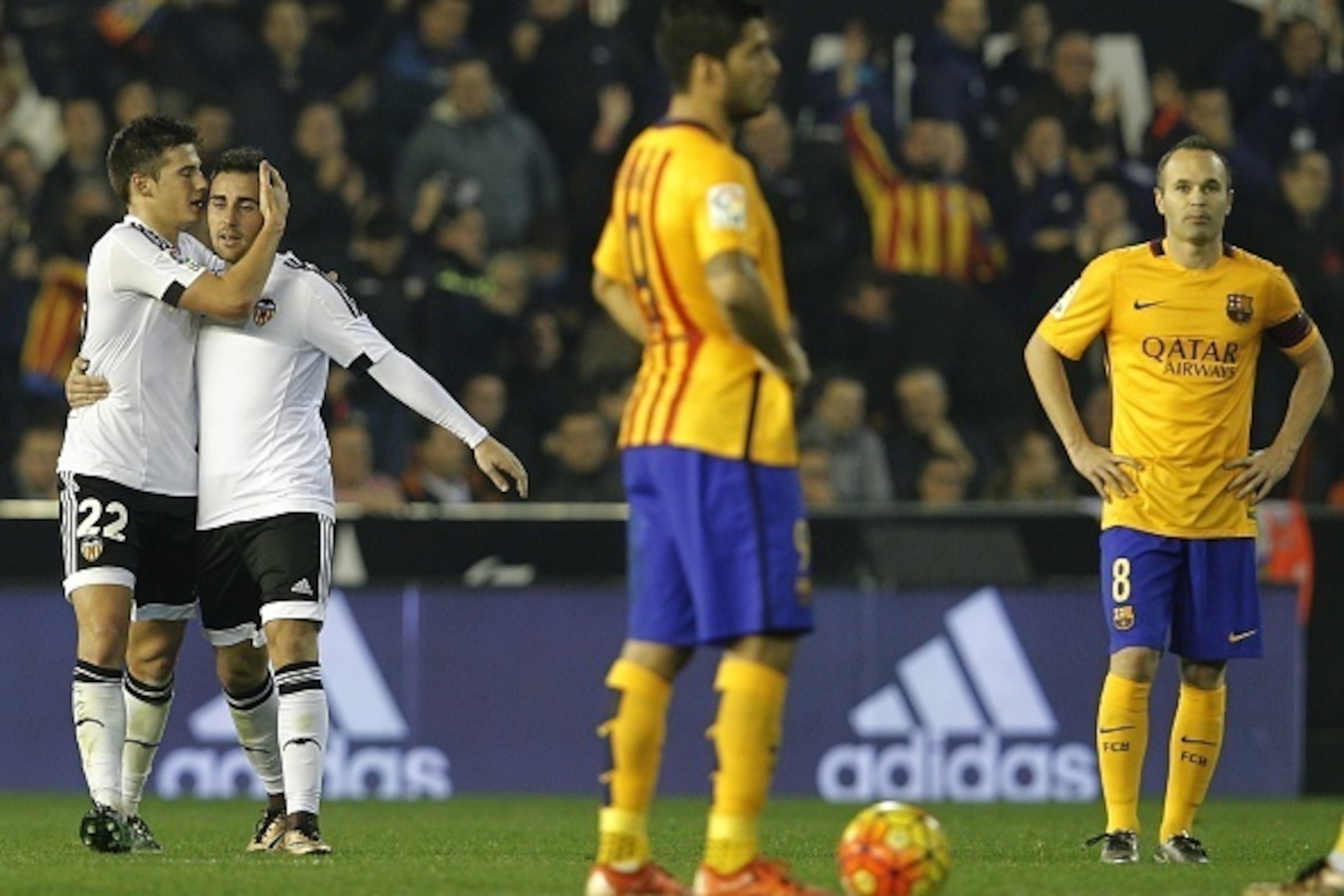 Valencia's forward Santi Mina (L) celebrates his goal with Valencia's forward Paco Alcacer (2nd L) as they walk past Barcelona's midfielder Andres Iniesta (R) during the Spanish league football match Valencia CF vs FC Barcelona at the Mestalla stadium in 