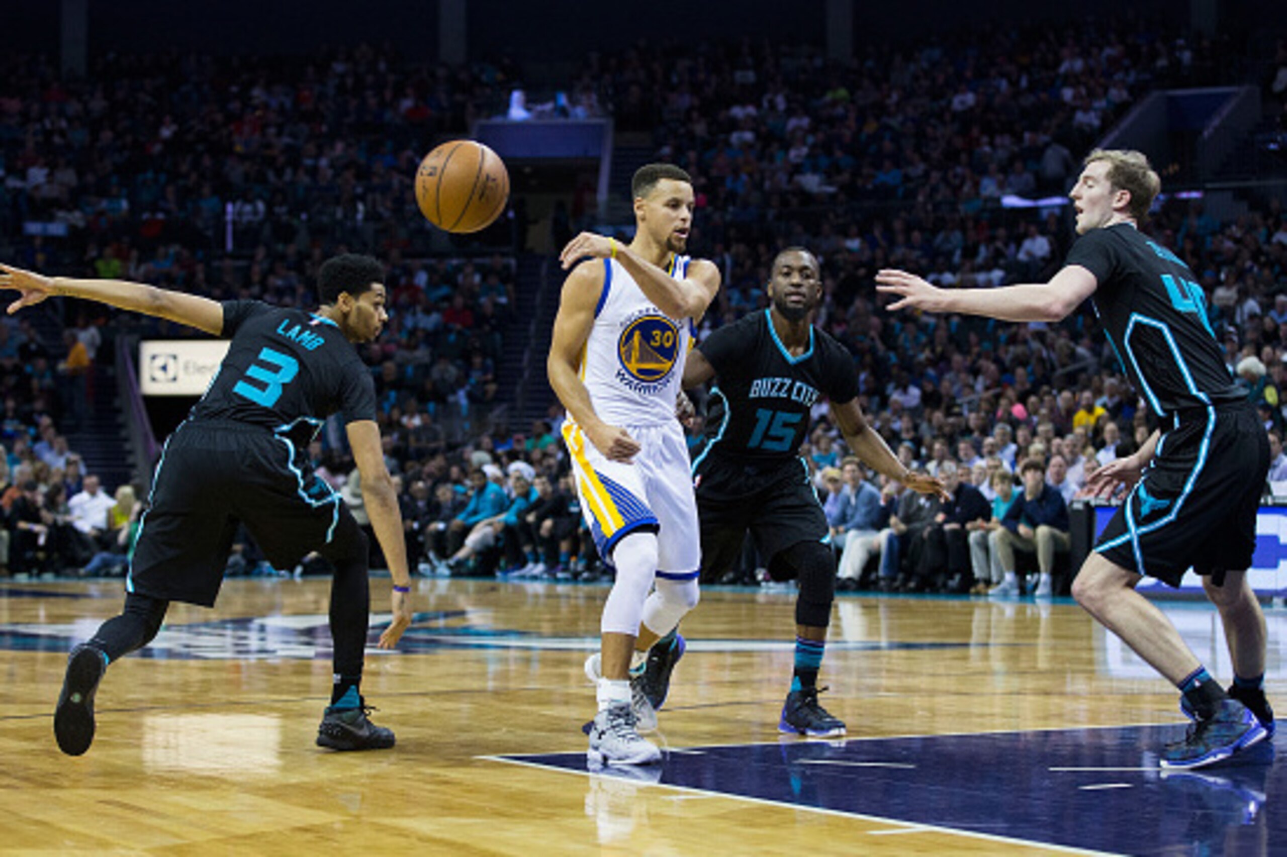 CHARLOTTE, NC - DECEMBER 02: Stephen Curry (30) of the Golden State Warriors makes a no look pass as he is defended by Jeremy Lamb (3), kemba Walker (15) and Cody Zeller (40) of the Charlotte Hornets at Time Warner Cable Arena on December 2, 2015 in Charl