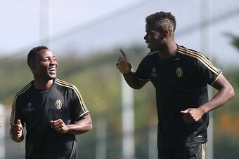 Juventus' midfielders Kwadwo Asamoah (L) from Ghana and French Paul Pogba take part in a training session on the eve of an UEFA Champions League football match against Manchester City on September 14, 2015 at the 'Juventus Training Center' in Vinovo, near