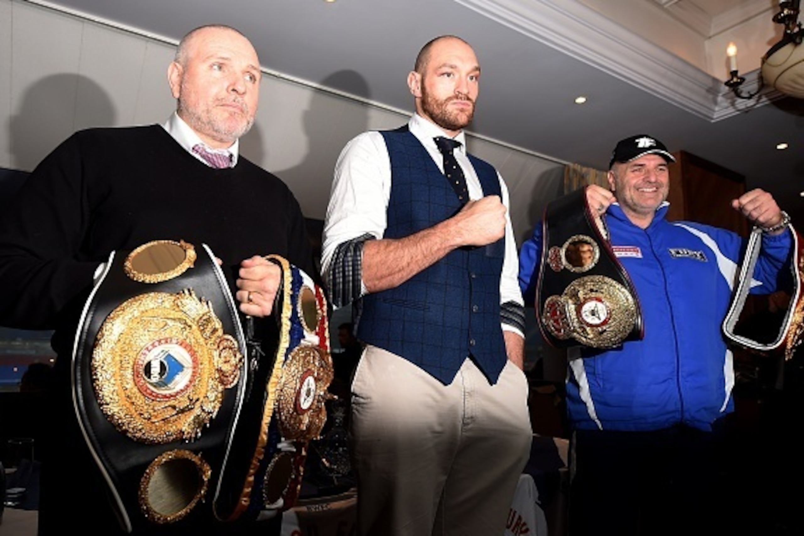 Britain's world heavyweight champion Tyson Fury (C) poses with his trainer and uncle Peter Fury (L) and father John Fury with championship belts during a press conference in Bolton, north west England on November 30, 2015. Tyson Fury was crowned the new w Britain's world heavyweight champion Tyson Fury (C) poses with his trainer and uncle Peter Fury (L) and father John Fury with championship belts during a press conference in Bolton, north west England on November 30, 2015. Tyson Fury was crowned the new w