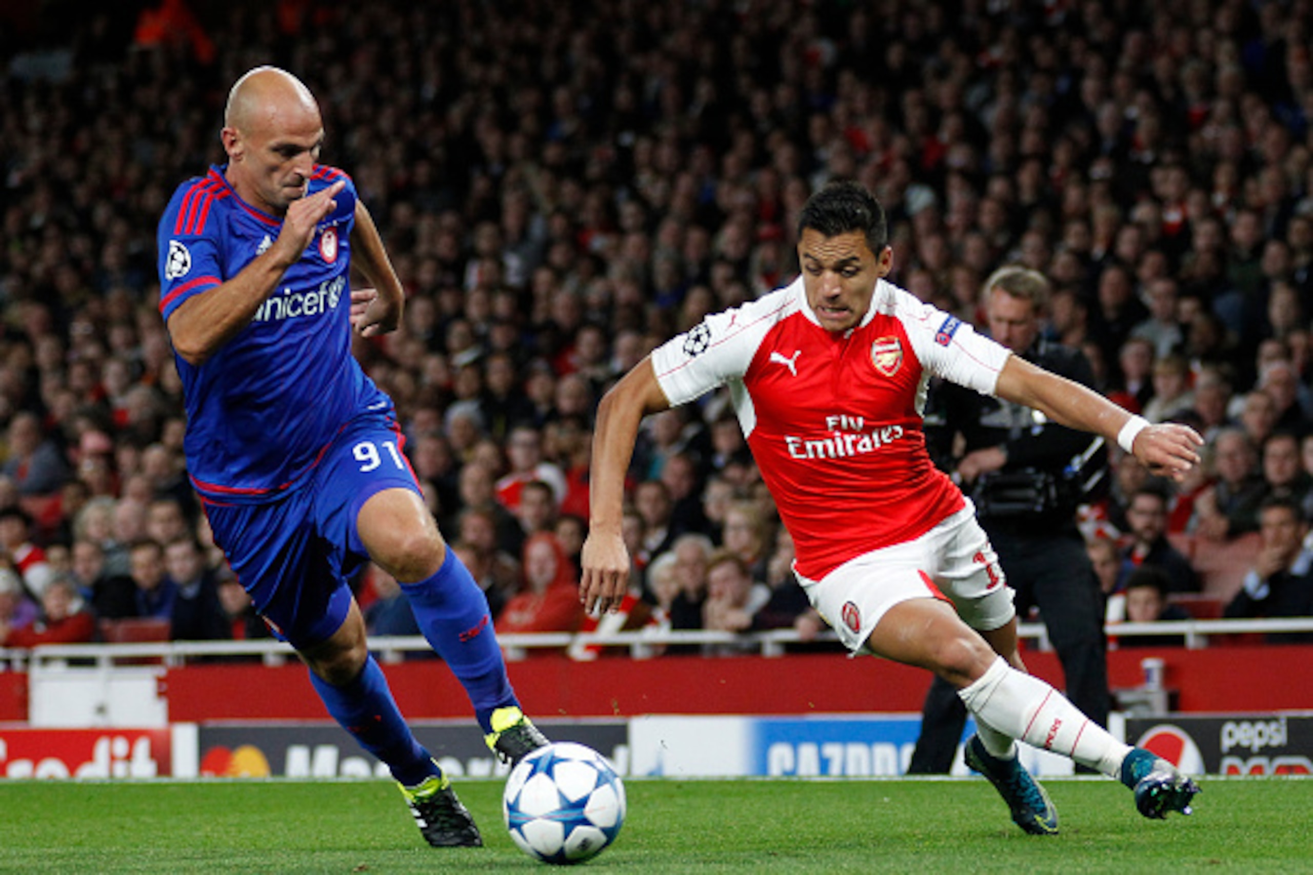 LONDON, ENGLAND - SEPTEMBER 29: Esteban Cambiasso  of Olympiakos and Alexis Sanchez of Arsenal during the Champions League match between Arsenal and Olympiacos at The Emirates Stadium on September 29, 2015 in London, United Kingdom. (Photo by Mitchell Gun