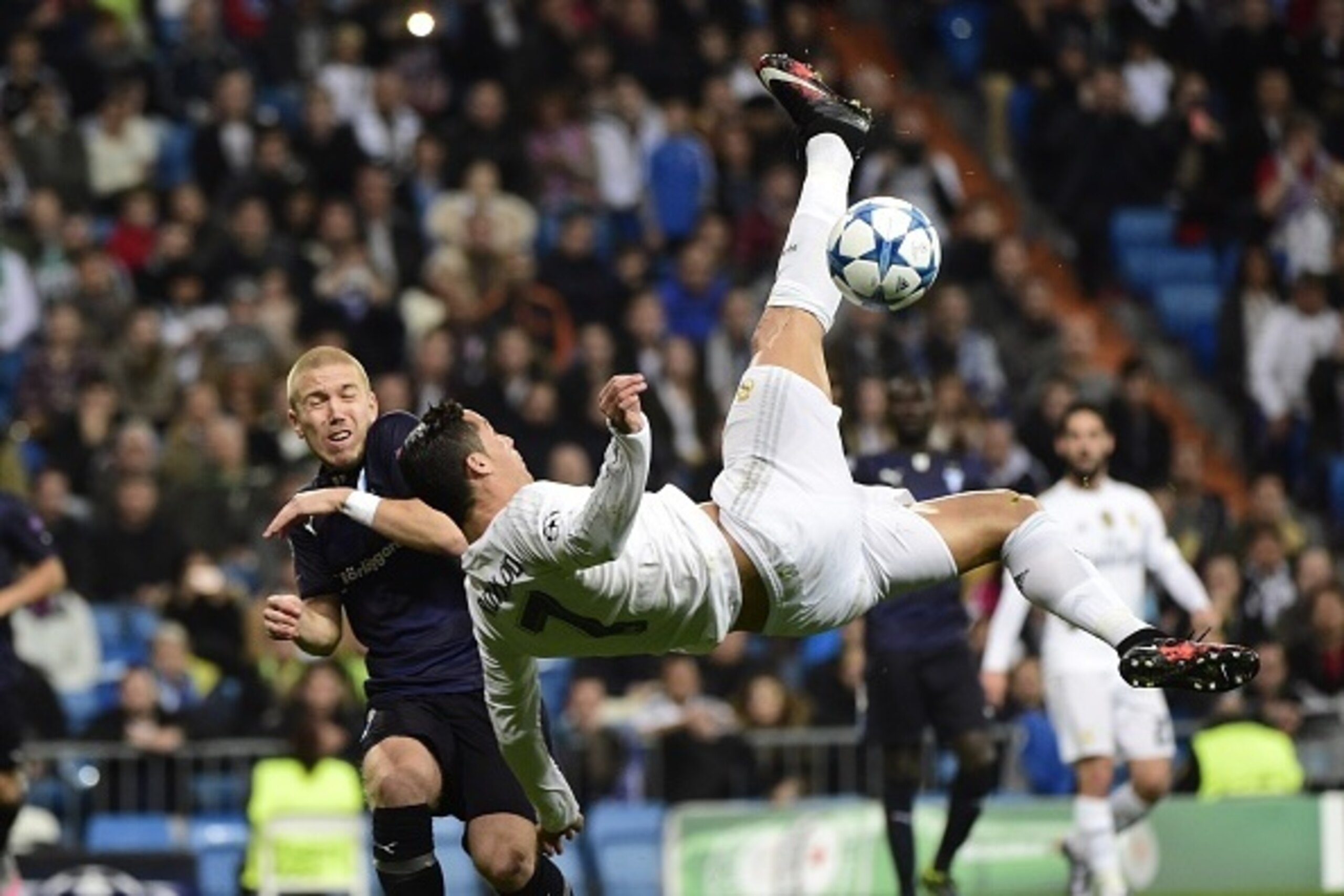 Real Madrid's Portuguese forward Cristiano Ronaldo (R) kicks the ball past Malmo's defender Anton Tinnerholm during the UEFA Champions League Group A football match Real Madrid CF vs Malmo FF at the Santiago Bernabeu stadium in Madrid on December 8, 2015.