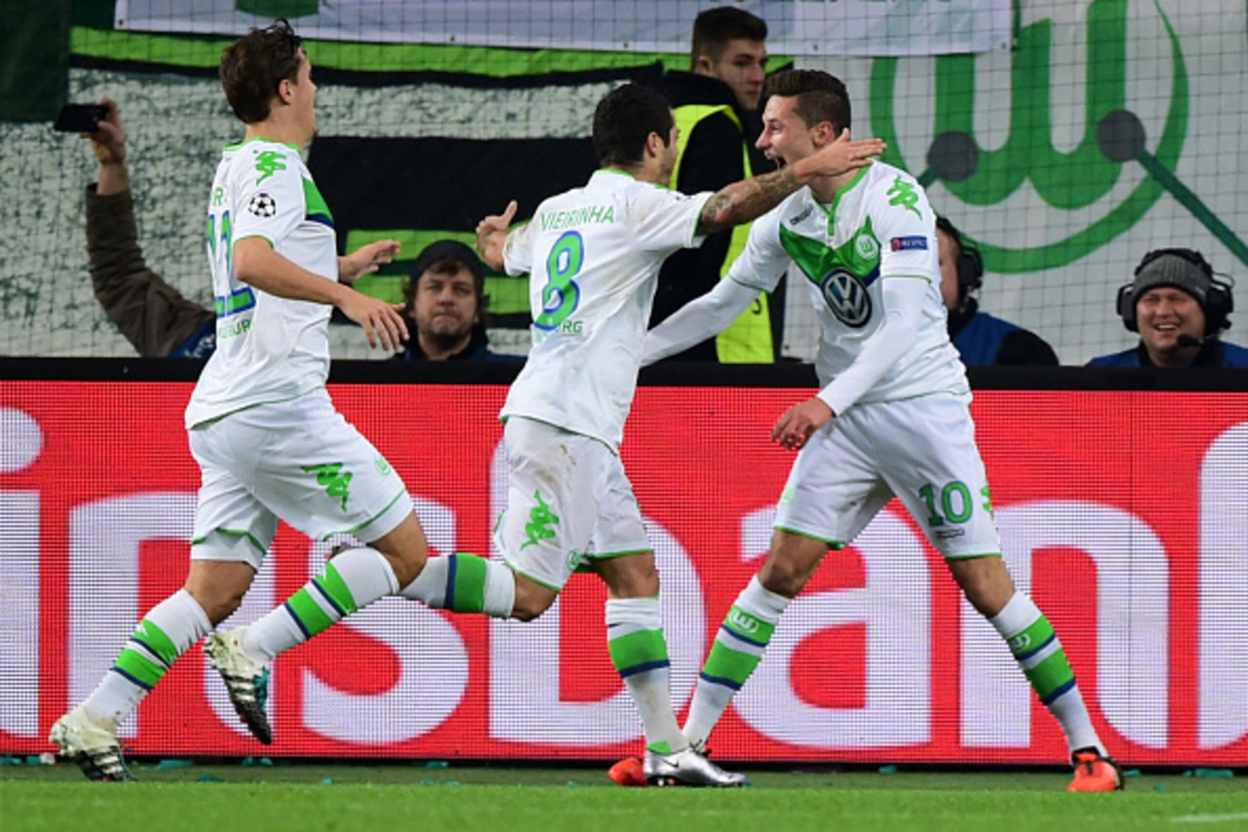 Wolfsburg's Portuguese striker Vieirinha (C) celebrates scoring with Wolfsburg's midfielder Julian Draxler (R) during the UEFA Champions League Group B second-leg football match VfL Wolfsburg vs Manchester United in Wolfsburg, central Germany, on December