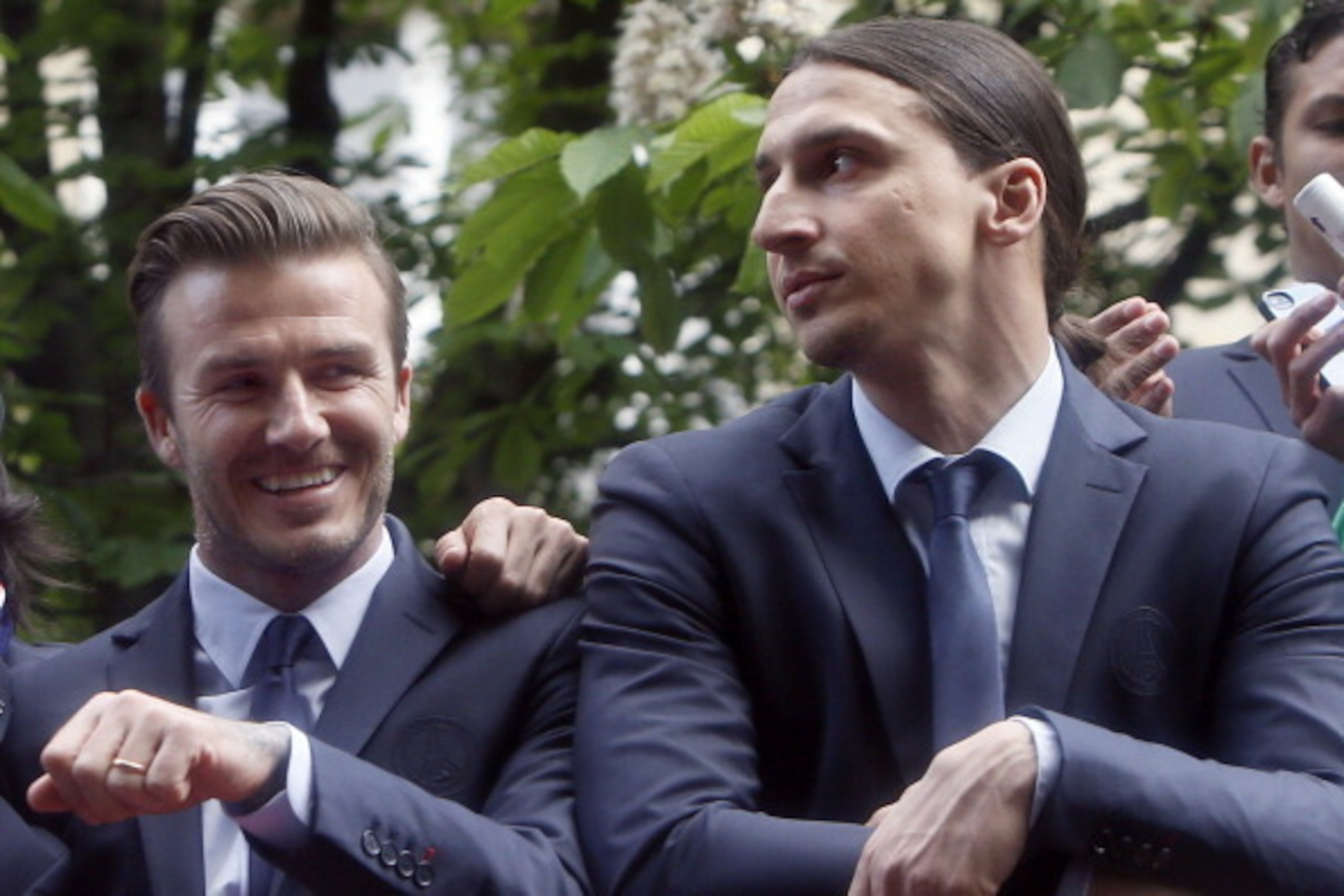 Paris Saint-Germain's British midfielder David Beckham (L) parades with teammate Swedish forward Zlatan Ibrahimovic on a double decker bus on May 13, 2013 in Paris, one day after Paris secured French L1 football championship title. AFP PHOTO / KENZO TRIBO
