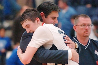 Characterized as "humble and kind to everyone" by his mother, Tracy, Luke Kornet and his father share a hug during Senior Night at Liberty Christian Academy.