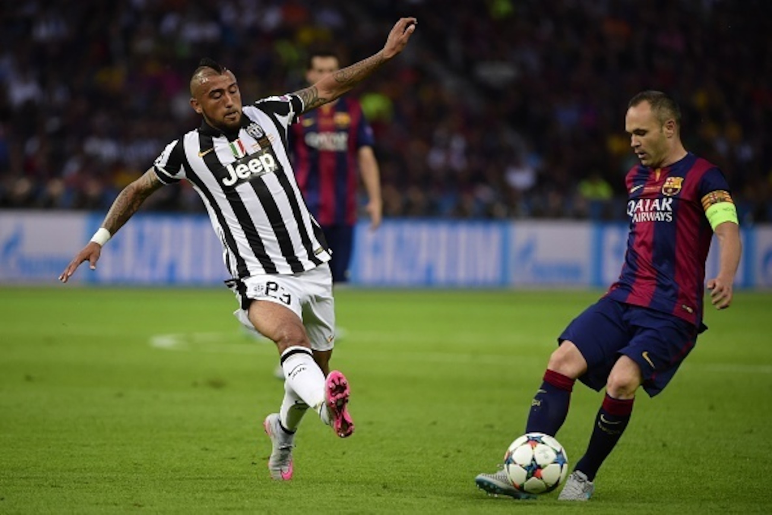 Juventus' Chilean midfielder Arturo Vidal (L) and Barcelona's midfielder Andres Iniesta vie for the ball during the UEFA Champions League Final football match between Juventus and FC Barcelona at the Olympic Stadium in Berlin on June 6, 2015.     AFP PHOT