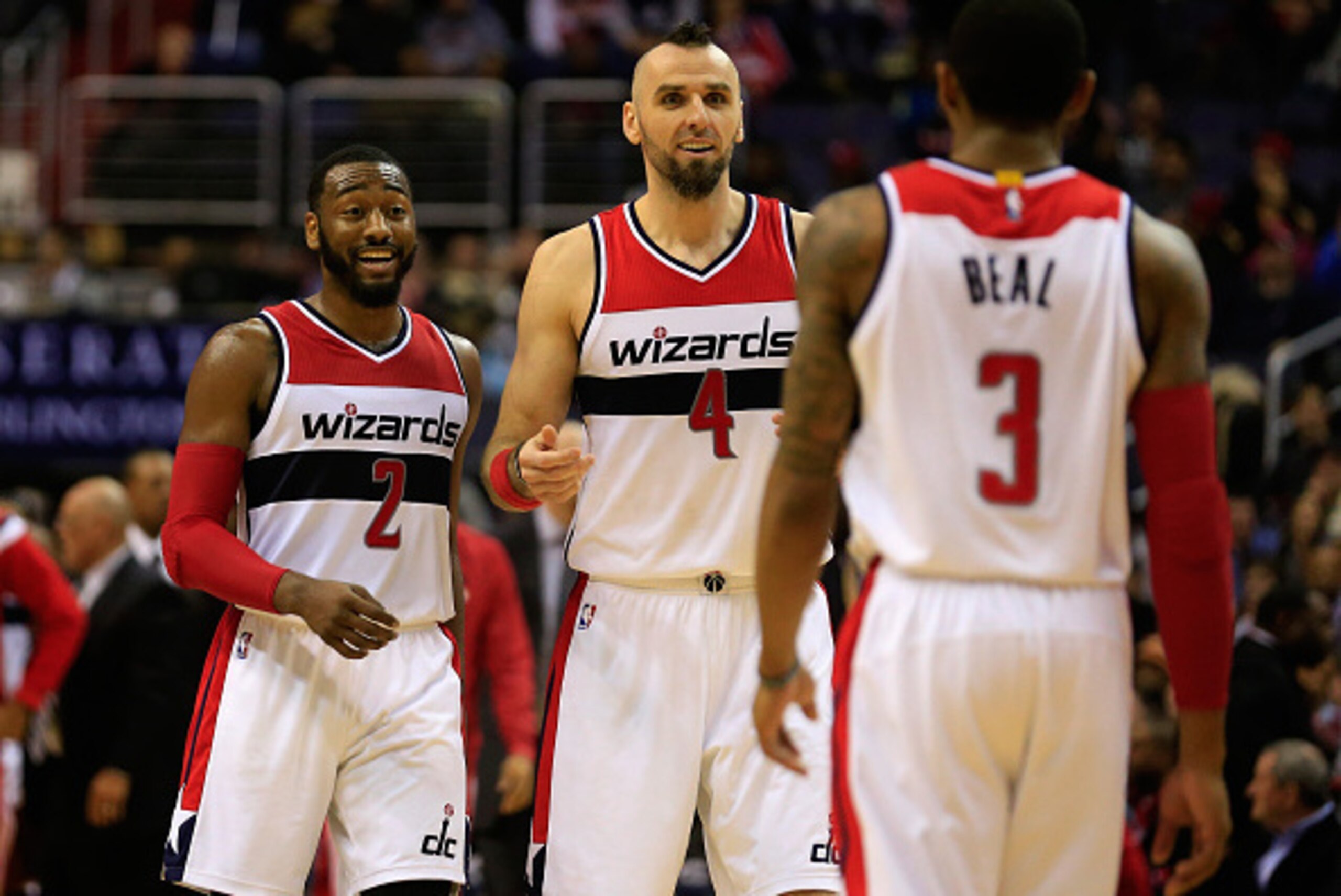 WASHINGTON, DC - DECEMBER 16: John Wall #2, Marcin Gortat #4, and Bradley Beal #3 of the Washington Wizards celebrate during the closing mintues of the Wizards 109-95 win over the Minnesota Timberwolves at Verizon Center on December 16, 2014 in Washington