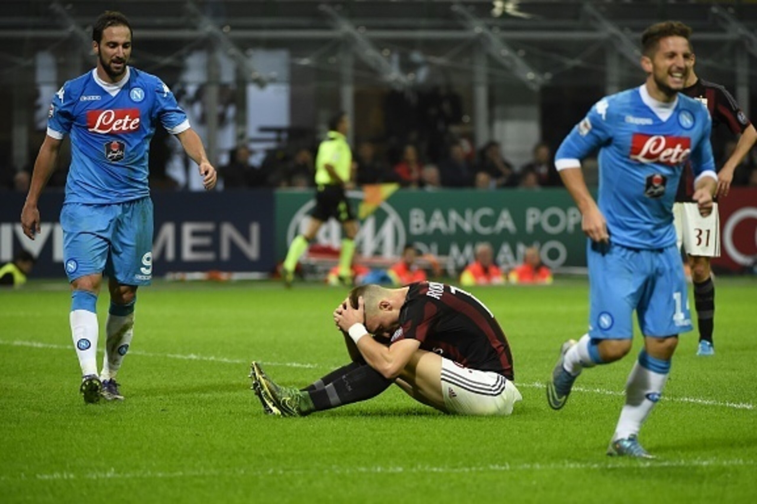 AC Milan's defender from Brazil Rodrigo Ely (C) reacts after scoring in his own goal as Napoli's forward from Argentina Gonzalo Higuain (L) walks past him during the Italian Serie A football match between AC Milan and Napoli at San Siro Stadium in Milan o