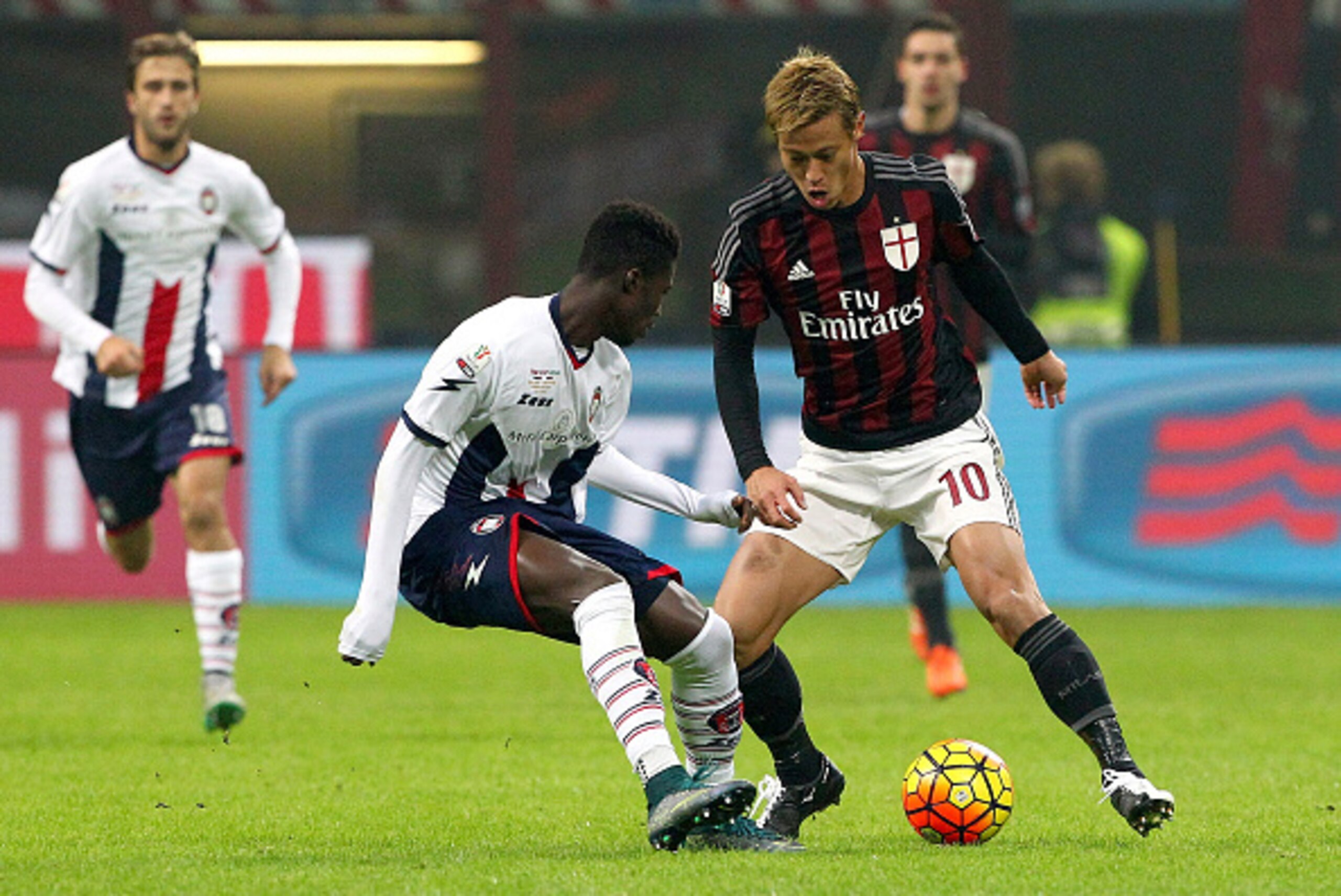 MILAN, ITALY - DECEMBER 01:   Keisuke Honda (R) of AC Milan competes for the ball with Eloge Koffi Guy Yao (L) of Eloge Koffi Guy Yao during the TIM Cup match between AC Milan and FC Crotone at Stadio Giuseppe Meazza on December 1, 2015 in Milan, Italy.  