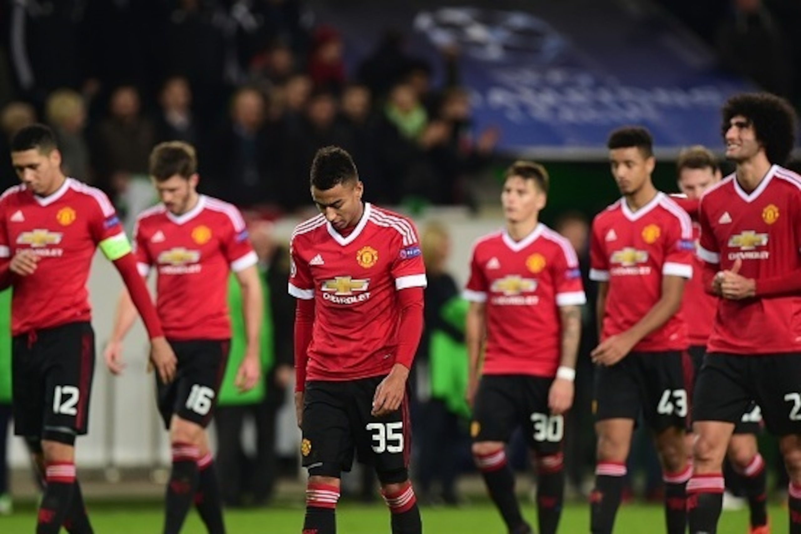TOPSHOT - Manchester United's players look dejected as they leave the pitch after the UEFA Champions League Group B second-leg football match VfL Wolfsburg vs Manchester United in Wolfsburg, central Germany, on December 8, 2015.  / AFP / JOHN MACDOUGALL  