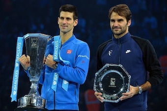 Serbia's Novak Djokovic (L) holds the ATP trophy with runner up Switzerland's Roger Federer after winning the men's singles final match against on day eight of the ATP World Tour Finals tennis tournament in London on November 22, 2015. 
AFP PHOTO / GLYN K